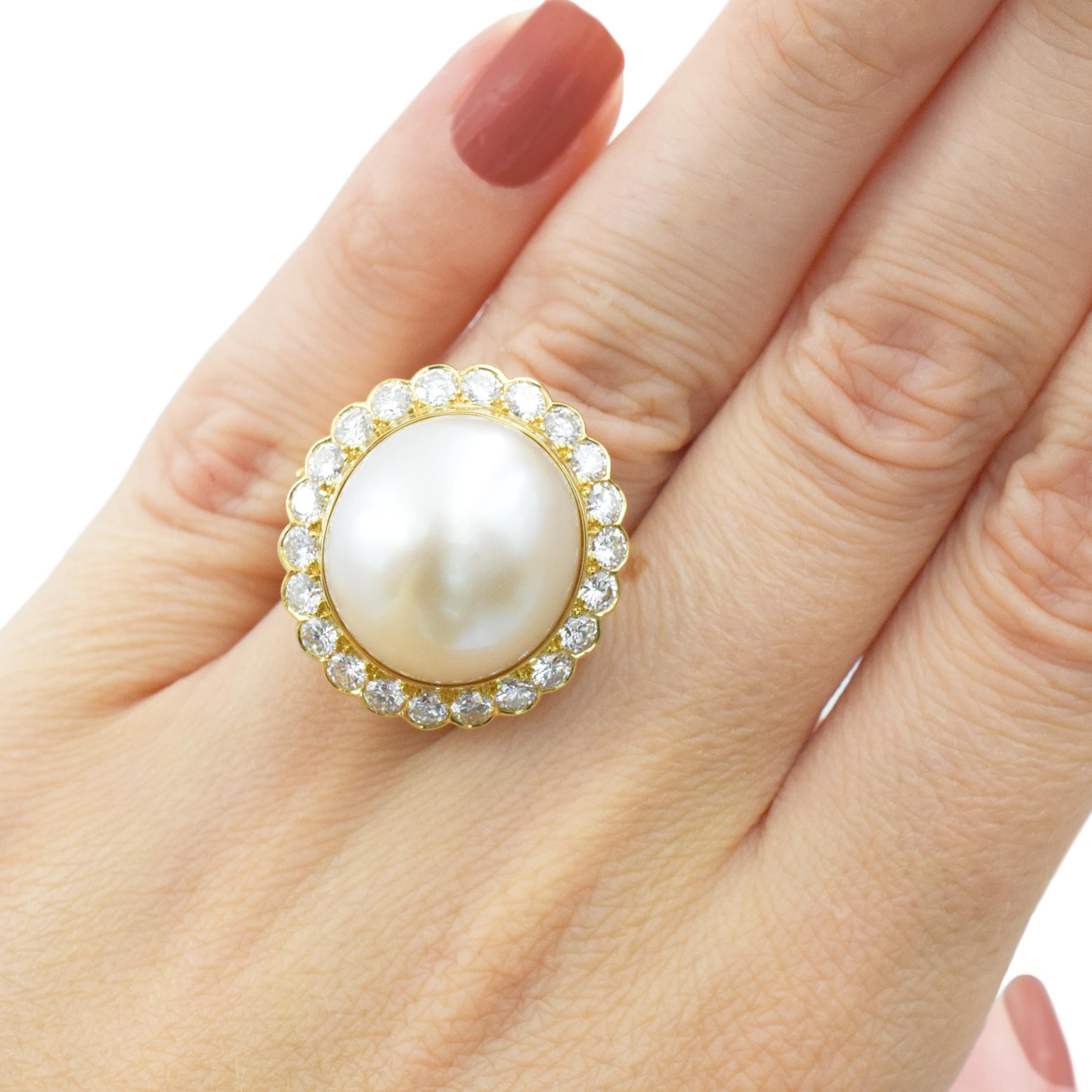Van Cleef & Arpels Perlen- und Diamantring aus 18k Gelbgold. In der Mitte dieses Rings befindet sich eine ovale Zuchtperle, die etwa 17,4 x 14,5 mm groß ist. Die Perle hat eine cremig-weiße Farbe mit zarten rosa Untertönen und gutem Glanz. Umgeben