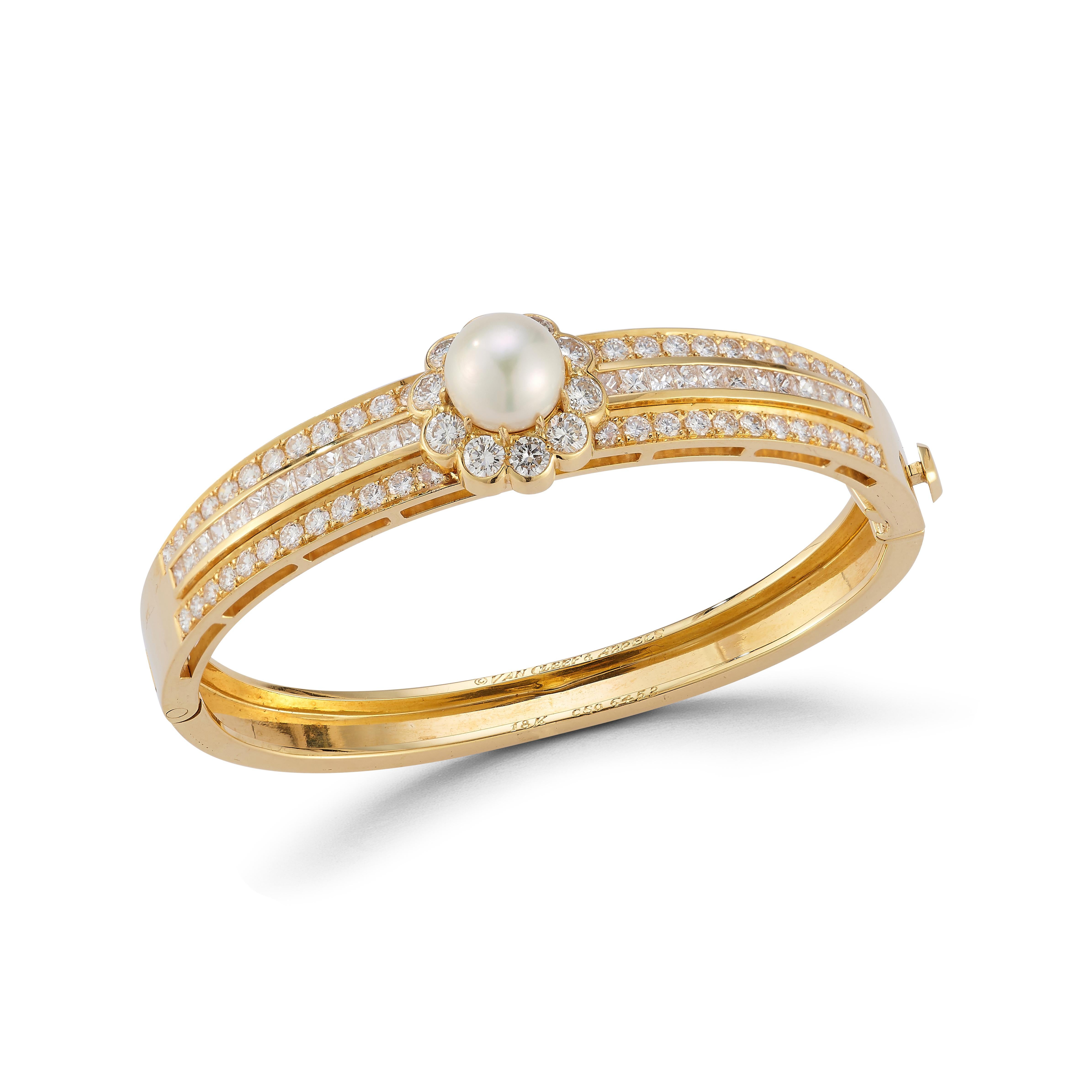 Van Cleef & Arpels Pearl & Diamond Bangle

An 18 karat yellow gold bangle set with a pearl in a halo of 10 round cut diamonds, flanked on either side by 48 round cut diamonds and 24 square cut diamonds

Signed Van Cleef & Arpels and numbered
Stamped