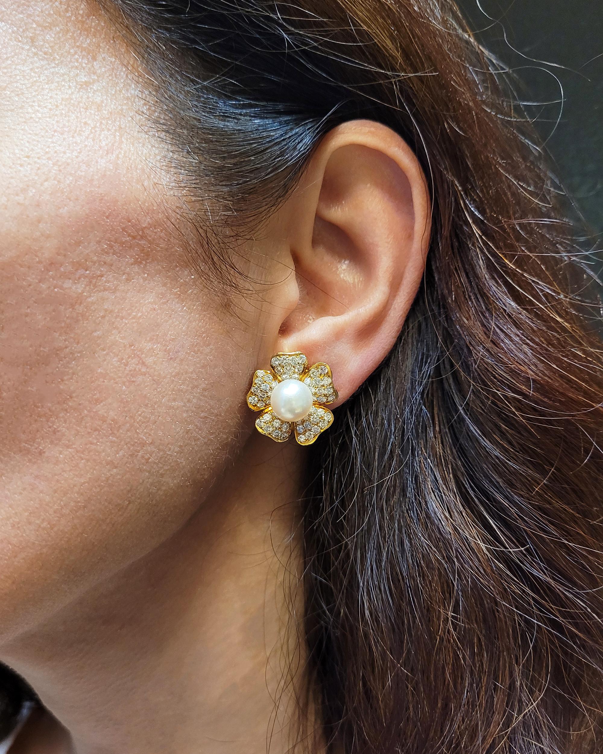 A beautiful pair of Van Cleef & Arpels earrings set with pearls and diamonds. 
Each set with a pearl center surrounded by round diamonds, most with E-F color, VS clarity.
Estimated weight of diamonds is 5.50 carats total.
Clip-on style.
18k yellow