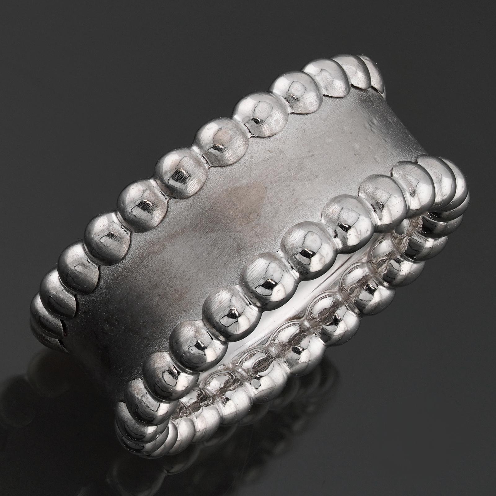 This fabulous Van Cleef & Arpels ring from the elegant Perle collection features a textured band and beaded edge design crafted in 18k white gold. Made in France circa 2000s. Measurements: 0.38
