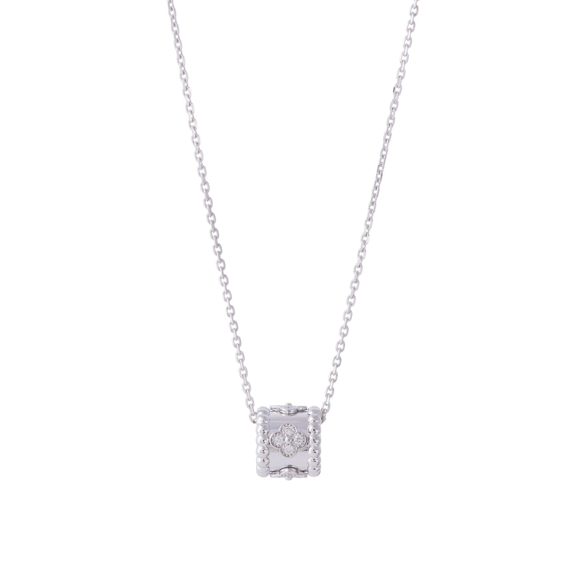 Authentic Van Cleef & Arpels Perlée Clovers pendant necklace crafted in 18 karat white gold and set with an estimated 0.19 carats of round brilliant diamonds.   The pendant is situated on a delicate 18 karat white gold adjustable chain measuring