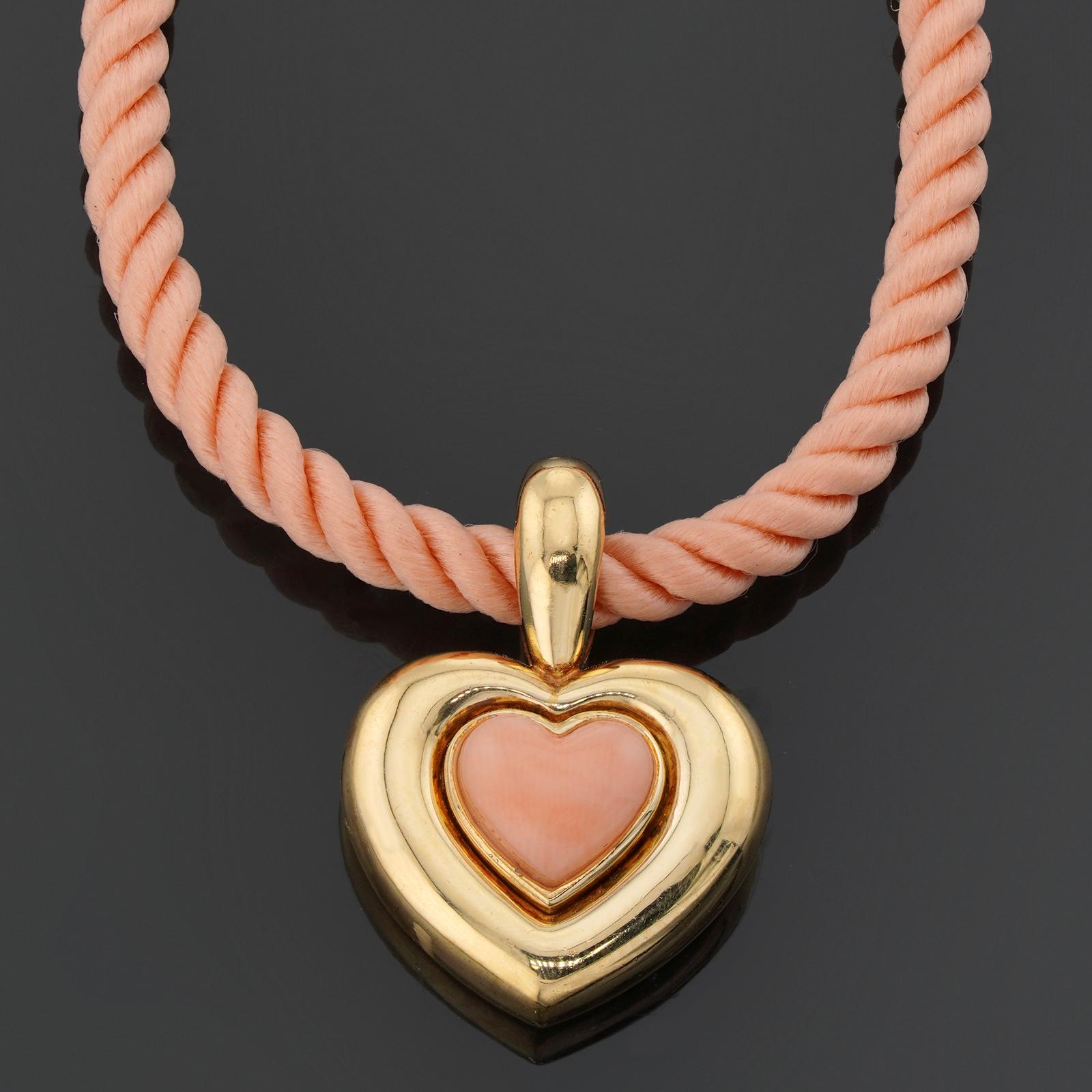 This gorgeous Van Cleef & Arpels necklace features a heart pendant crafted in 18k yellow gold and set with a pink coral and completed with an original VCA pink silk cord. Made in France circa 1990s. Measurements: 0.62