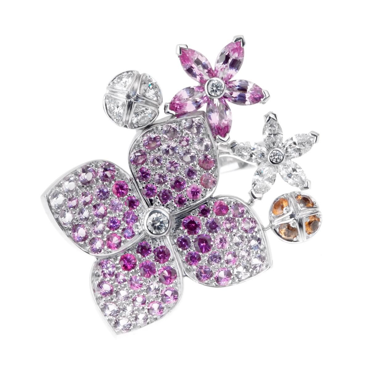 A stunning display of craftsmanship in this fabulous Van Cleef & Arpels diamond ring showcasing graduating colors of pink sapphire illuminated by round brilliant cut diamonds in 18k white gold. A plethora of multi color and multi shaped sapphires