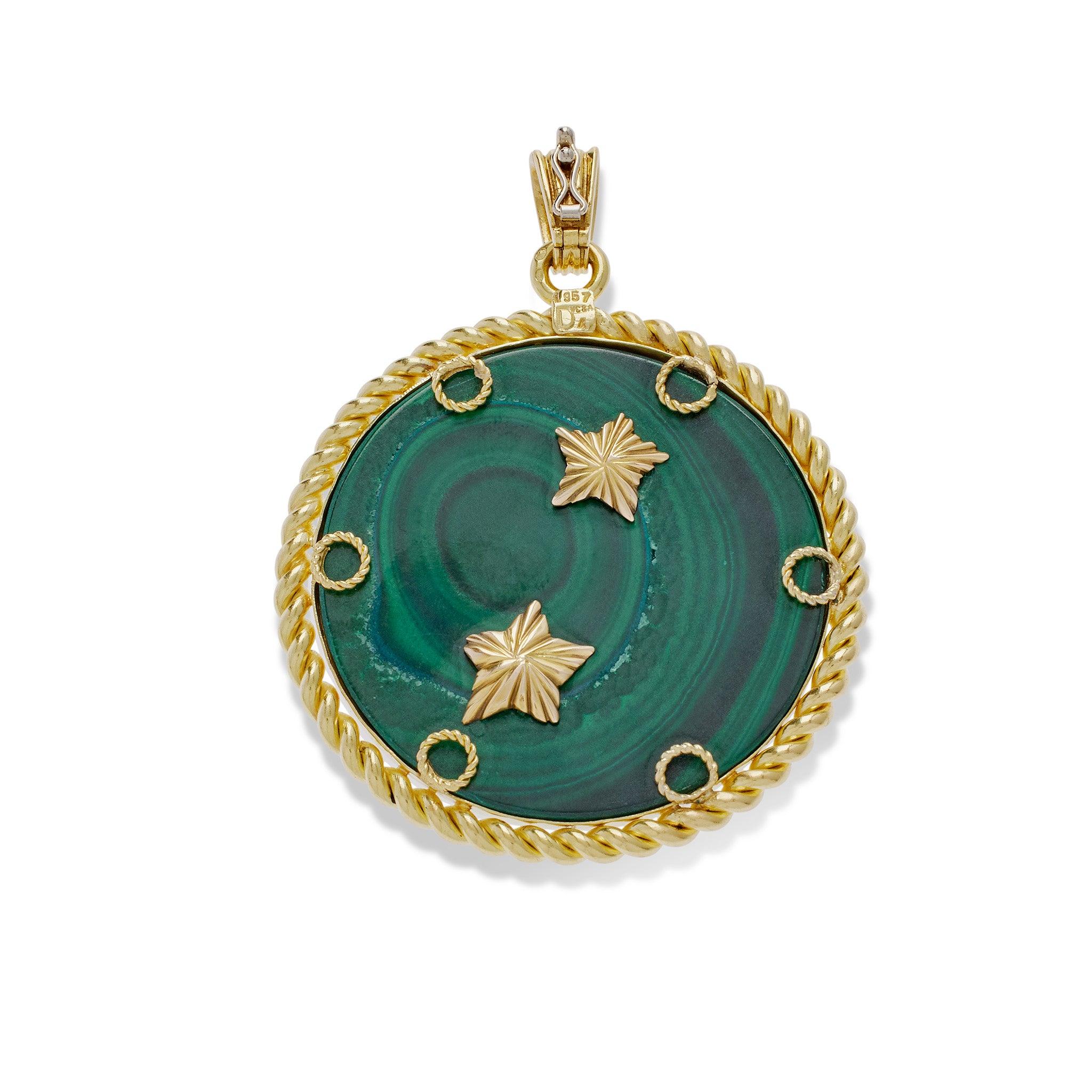 Dating from the 1970s, this Pisces pendant by Van Cleef & Arpels is composed of 18K gold, diamond, and emeralds. The ribbed bail suspends a circular pendant, within ropetwist frame, depicting a pair of fish in high relief textured 18K gold, with