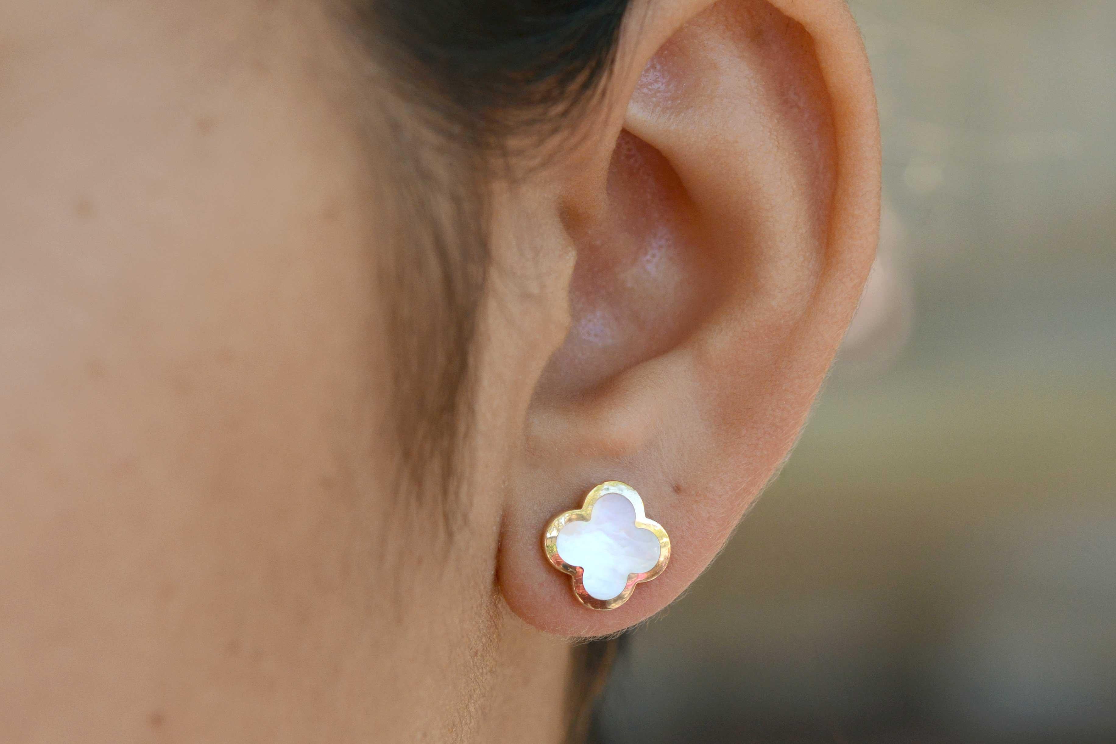 A lovely pair of authentic Van Cleef & Arpels mother of pearl earstuds. With the Pure Alhambra® jewelry creations designed in 2001, a new interpretation of the Alhambra symbol. Inspired by the clover leaf, they give pride of place to the purity and
