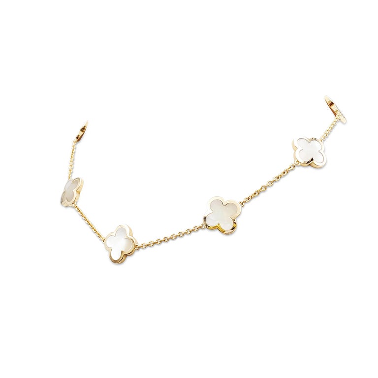 Authentic Van Cleef & Arpels Pure Alhambra necklace crafted in 18 karat yellow gold featuring 9 clover-inspired motifs of carved mother of pearl.  The necklace measures 16 inches in wearable length.  Signed VCA, 750, with serial number and French