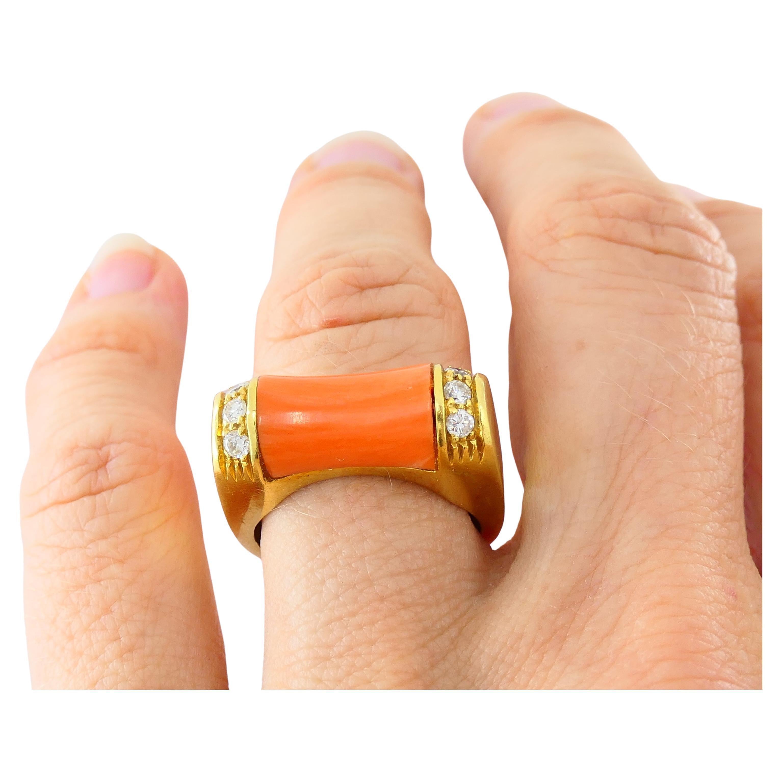 Bague Van Cleef & Arpels en or 18 carats et corail, rehaussée de diamants.
Le corail, en forme de maillon de bambou, est incrusté de trois diamants sertis verticalement sur les côtés.
Le devant carré de la bague se transforme en une tige ronde, ce