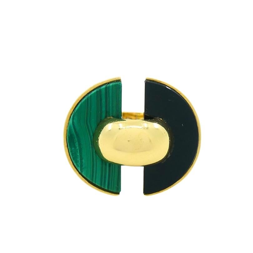 A Van Cleef & Arpels malachite and onyx ring, made of 18k gold.
The VCA ring features two semi-circular inlays of rich green malachite and sleek black onyx. These contrasting gemstones are arranged to form a strong geometric composition, enhanced by
