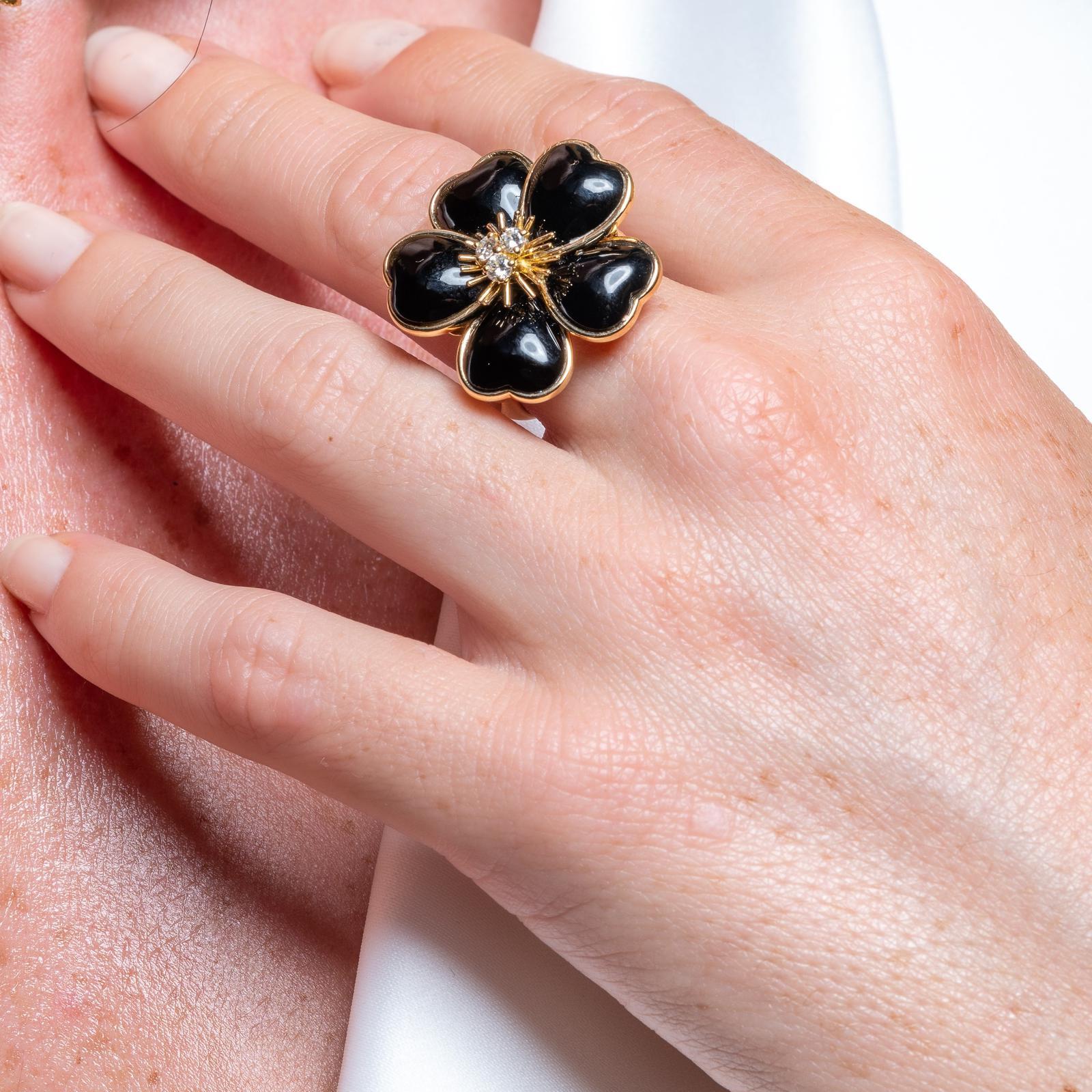 Ring signed by van Cleef & Arpels. Rose de Noel collection. in 750 thousandths yellow gold (18 carats). model of the 1970s. flower composed of 5 onyx petals. set in the center of 3 diamonds. brilliant cut. about 0.06 ct each. total weight diamonds: