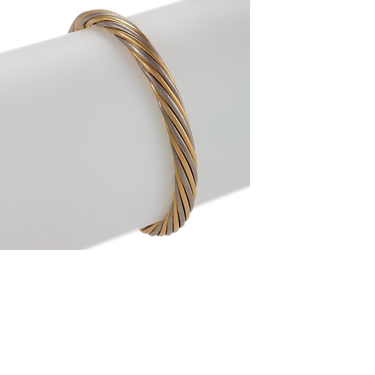 Dating from the 1970s-1980s, this bi-color gold rope twist bangle bracelet was created by Van Cleef & Arpels Paris. The bangle is designed as strands of yellow and white gold twisted symmetrically into a circular form. A clean, fresh look, this