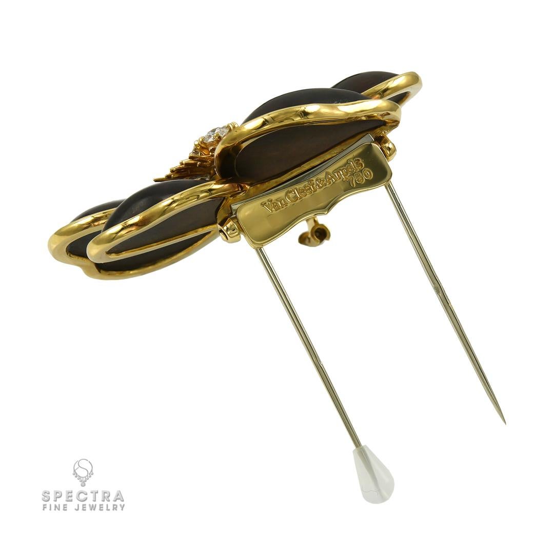 Una bella interpretación del encanto de la naturaleza, este broche de flor Van Cleef & Arpels Rose de Noël es una grácil mezcla de calidez y elegancia. El diseño presenta cinco ricos pétalos de madera pulida que evocan una suavidad orgánica, cada