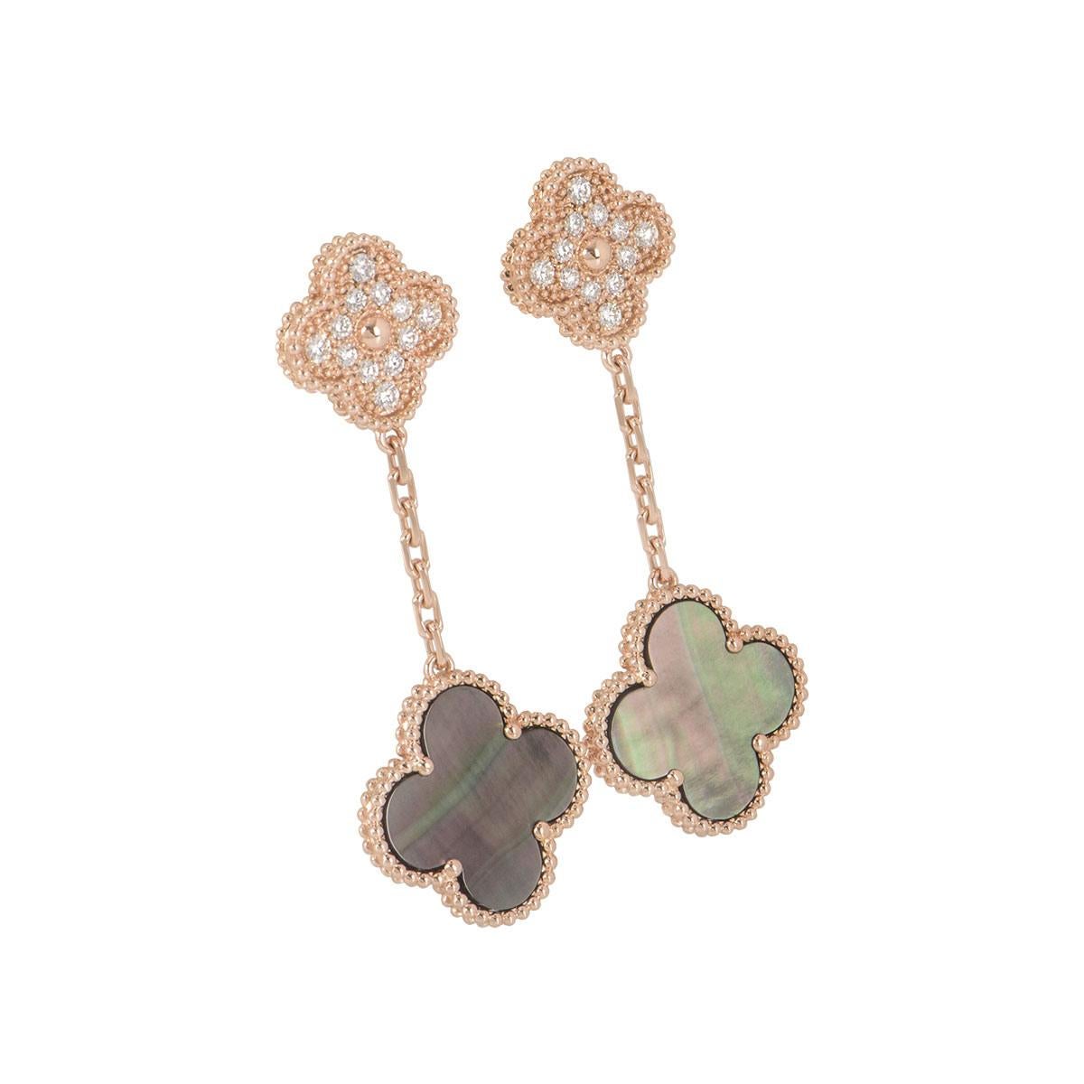 Un paio di orecchini in oro rosa 18k e diamanti di Van Cleef & Arpels della collezione Magic Alhambra. Gli orecchini sono composti da motivi a quadrifoglio in oro rosa con diamanti rotondi taglio brillante incastonati su ogni orecchino; sotto di