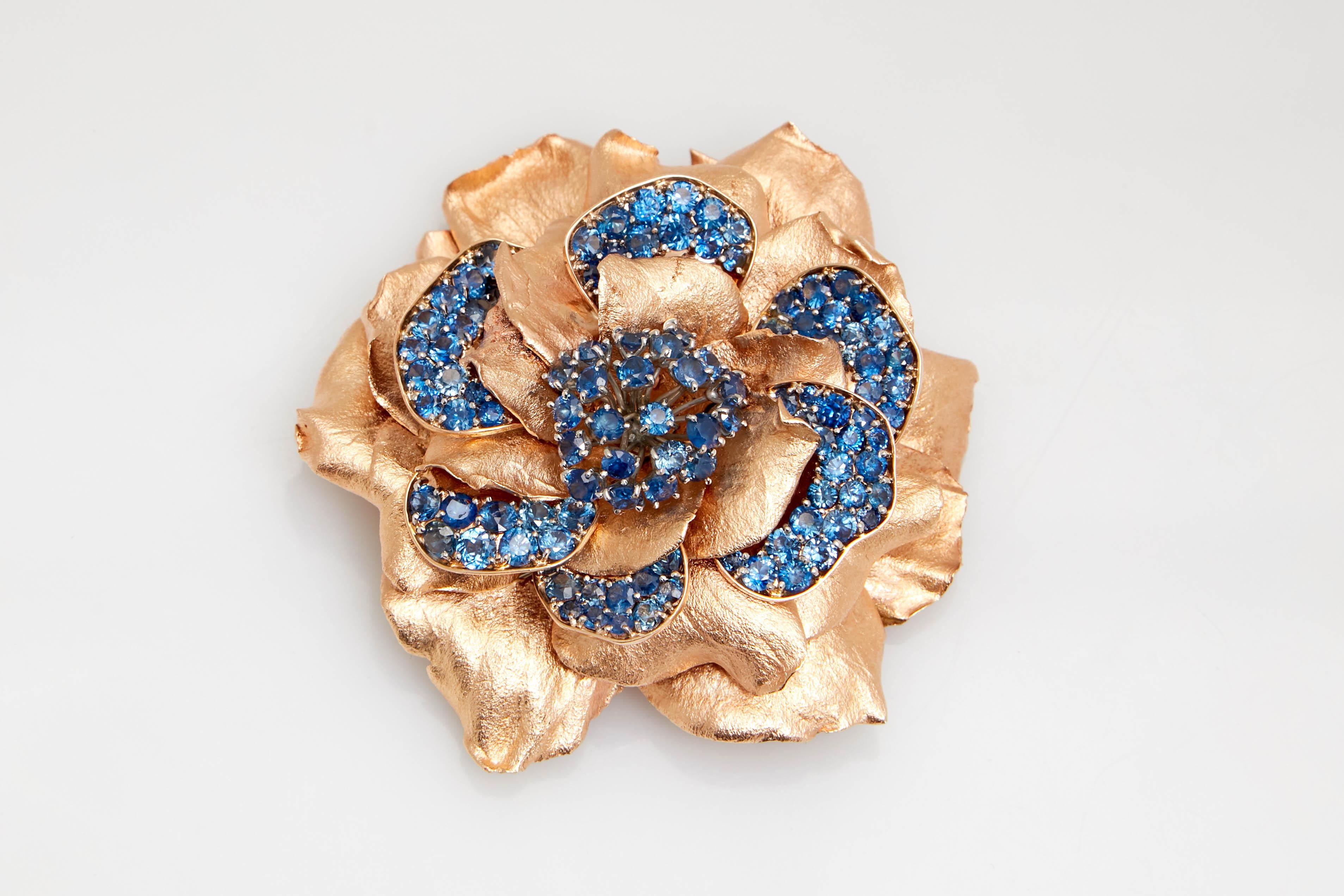 Retro Van Cleef & Arpels New York rose gold and sapphire flower clip-brooch. Made in the United States, circa 1955.
14 kt., the large flower fashioned of layers of folded petals, embellished by round sapphires approximately 16.90 cts., signed Van