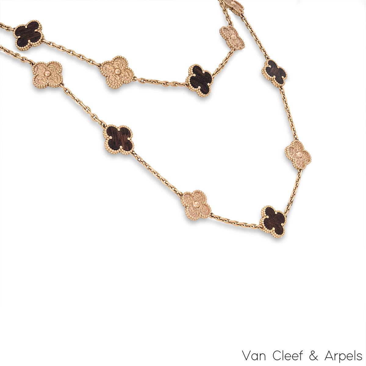 A limited edition 18k rose gold letterwood necklace by Van Cleef and Arpels from the Vintage Alhambra collection. The 20 motif necklace alternates between 10 textured clover motifs and 10 letterwood clover motifs, each set with a beaded edge. The