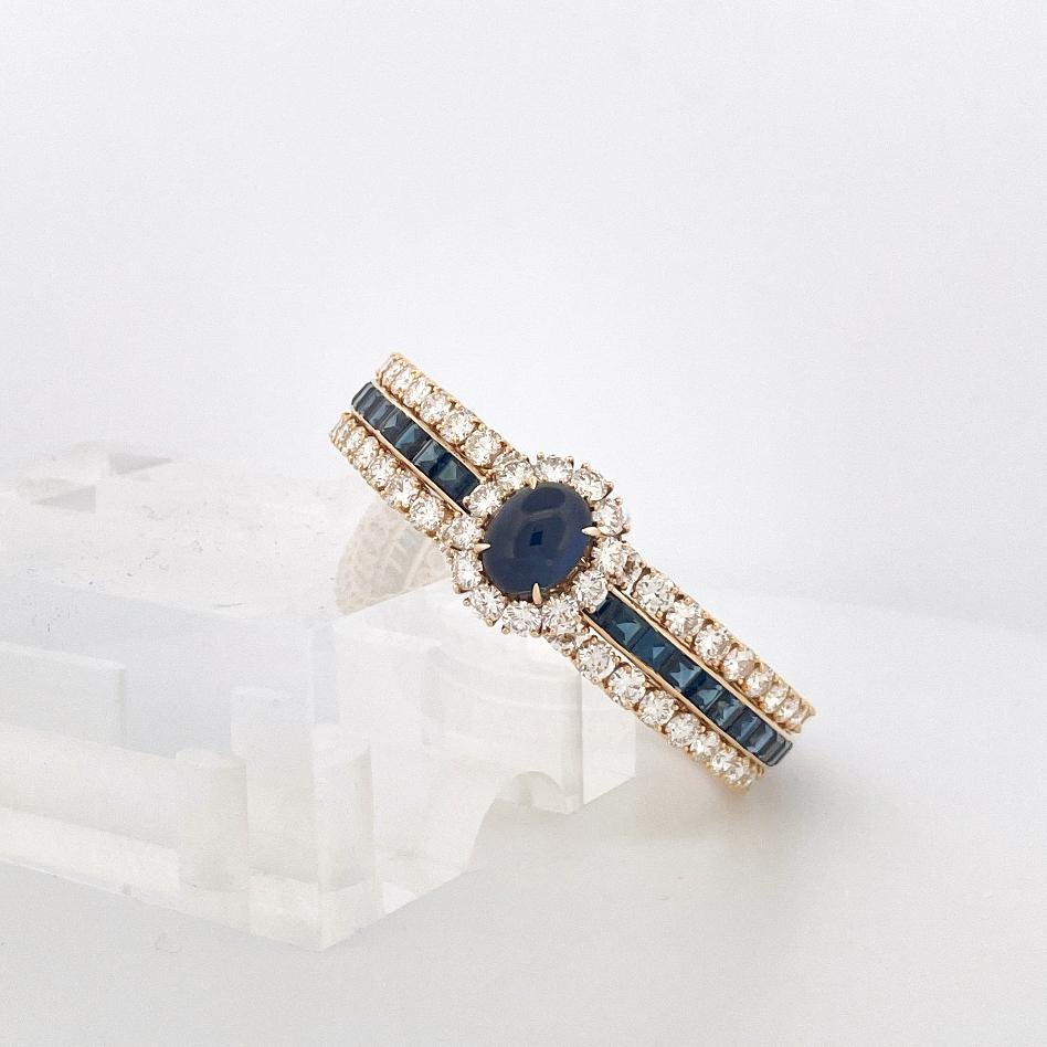 Dieser Armreif aus 18-karätigem Gelbgold der 1970er Jahre von Van Cleef & Arpels ist mit einem 5,33-karätigen Saphir im Cabochon-Schliff mit Heiligenschein besetzt. Der Umfang des Armbands ist mit zwei Reihen runder Diamanten im Brillantschliff mit