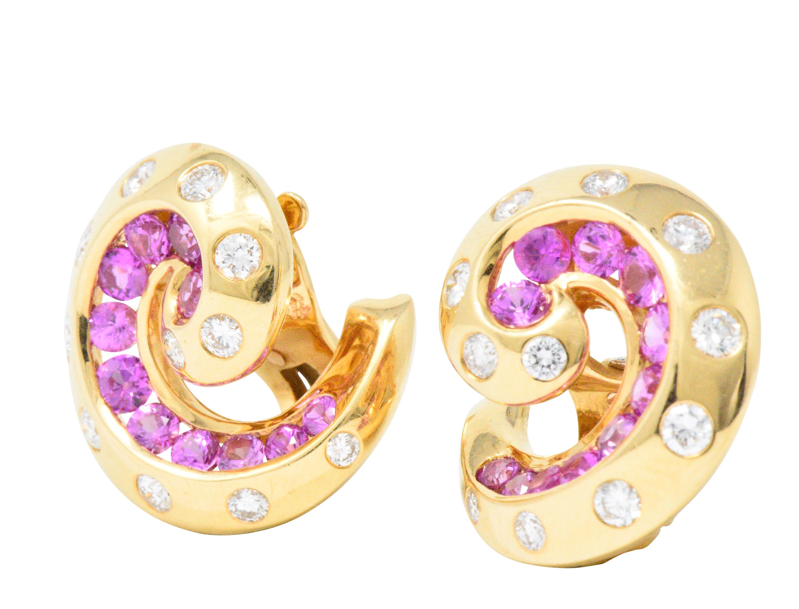 Designed as polished gold swirls each centering eleven channel set, graduated, round cut pink sapphires, twenty-two sapphires total weighing approximately 1.95 carats total, bright pink color and very well matched

Each with eleven bezel or flush