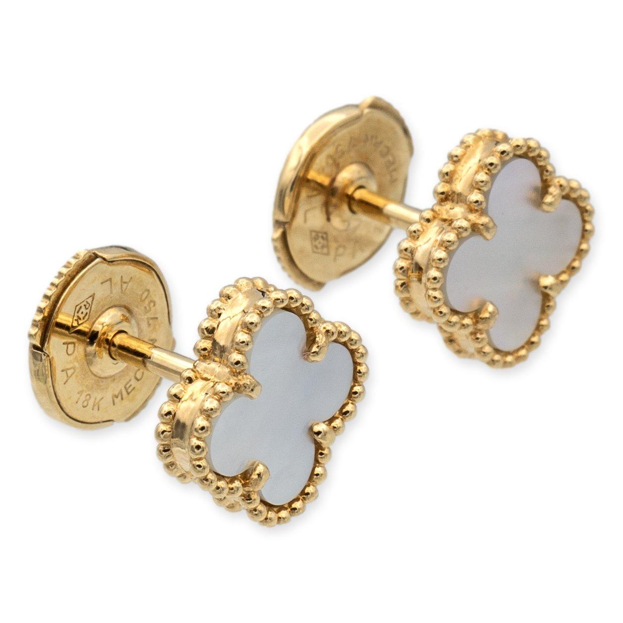 Van Cleef & Arpels stud earrings from the Alhambra collection finely crafted in 18 karat yellow gold featuring mother of pearl centers measuring 9.5 mm (0.37 in) with friction back posts and butterfly backs. Fully hallmarked with logo, serial
