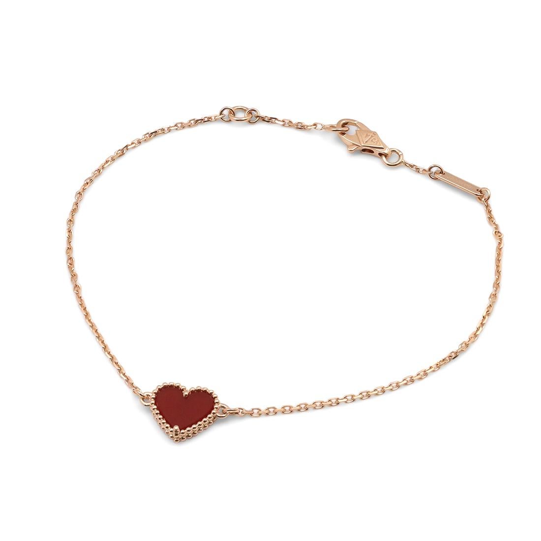 Authentic Van Cleef & Arpels 'Sweet Alhambra Heart' bracelet crafted in 18 karat rose gold features a single carnelian heart motif. Signed VCA, 750, with serial number. Will fit up to a 7 inch wrist. The bracelet is presented with the original