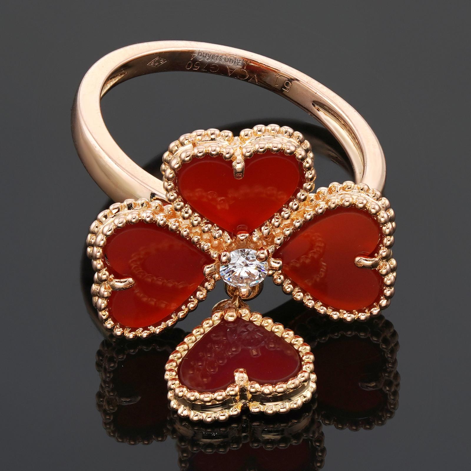 Questo squisito anello Van Cleef & Arpels della collezione Sweet Hearts è realizzato in oro rosa 18 carati e impreziosito da 4 cuori di corniola rossa e da un diamante centrale rotondo taglio brillante D-E-F VVS1-VVS2 del peso stimato di 0,08
