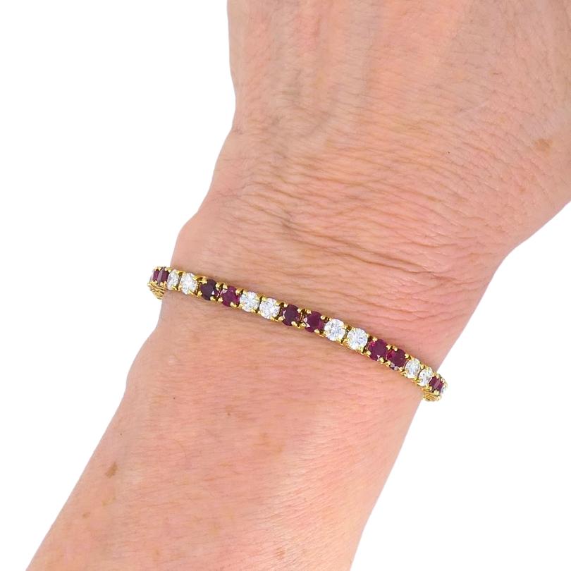 Ein zartes Tennisarmband von Van Cleef & Arpels aus 18 Karat Gold mit Rubin und Diamant.
Dieses Vintage-Tennisarmband zeigt ein abwechselndes Muster aus runden, facettierten Rubinen und runden Diamanten im Brillantschliff. Der tiefrote Farbton der