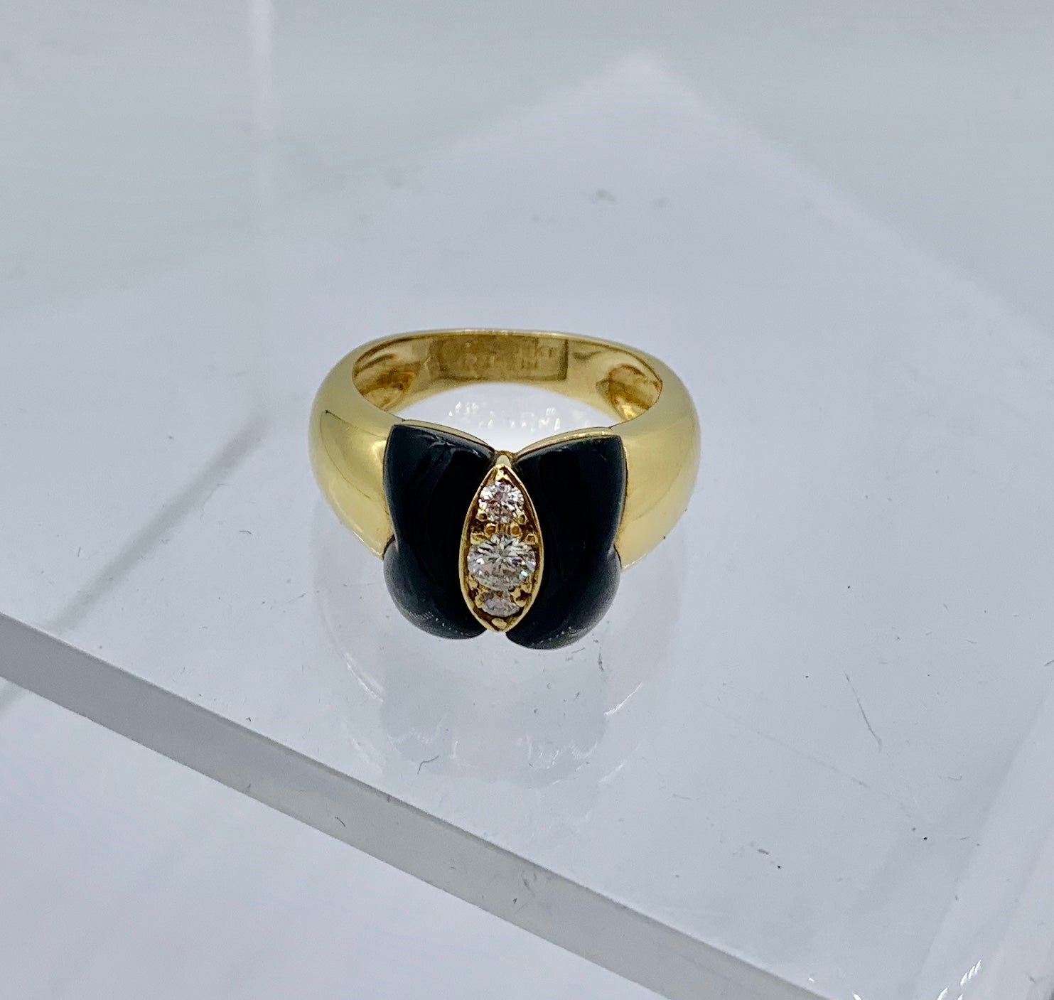 This is a stunning ring by Van Cleef & Arpels with three Diamonds, Black Onyx and 18 Karat Gold.  The ring is made in 
France.  The classic elegant jewel is a vintage Van Cleef jewel with dramatic black and white design that evokes the natural form