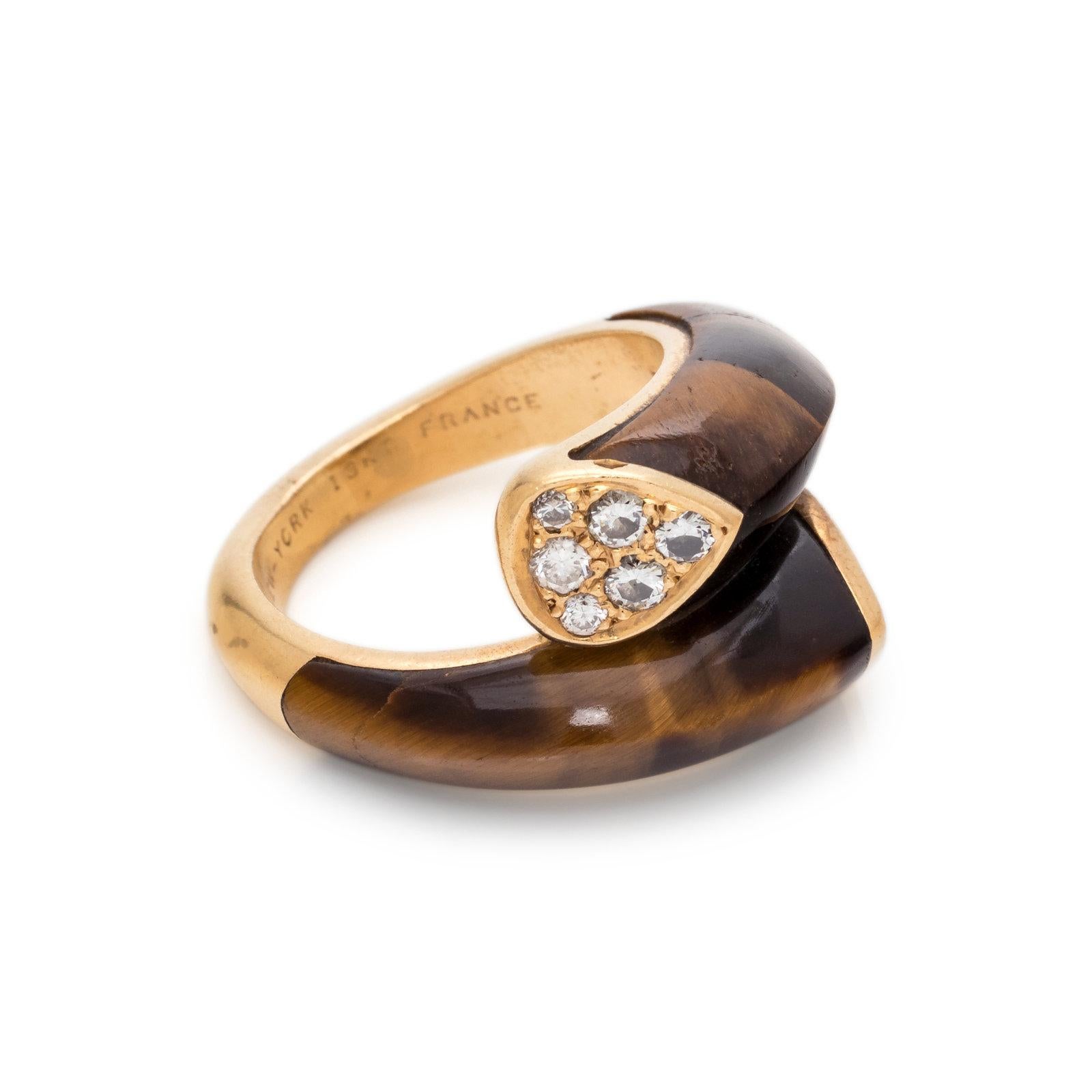 This 18K yellow gold and diamond ring features approximately 0.25 carats of diamonds and tiger’s eye plaques in a bypass design set in yellow gold. Size 4.75. Stamp: V. C. A. NEW - YORK 18KT. FRANCE 5V501.23
Interior is engraved: ALL MY LOVE ARNOLD