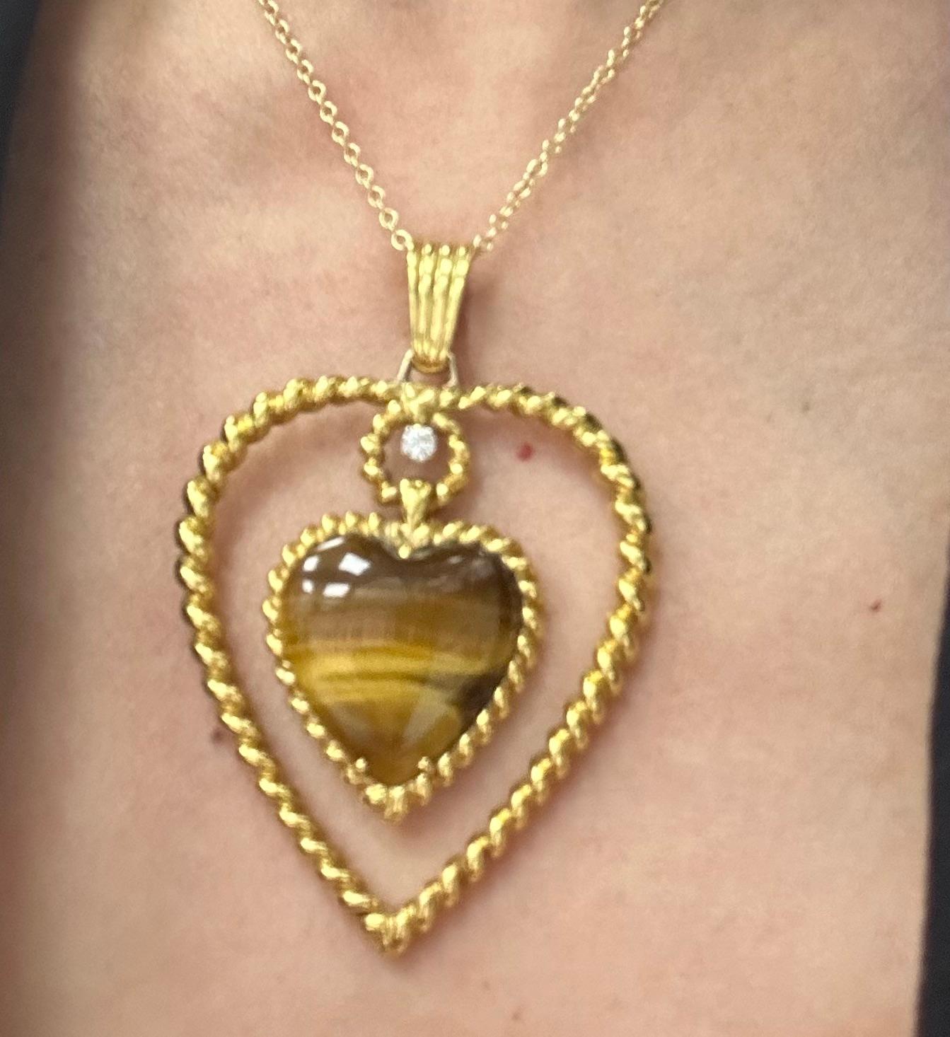 Van Cleef & Arpels tiger's eye heart pendant long necklace 

Pendant is made out of 18 karat yellow gold and has a heart-shaped tiger's eye as well as a round-cut diamond; width 1.75 inches, length 2 inches; marked VCA, 16V395-1
Chain is made out of