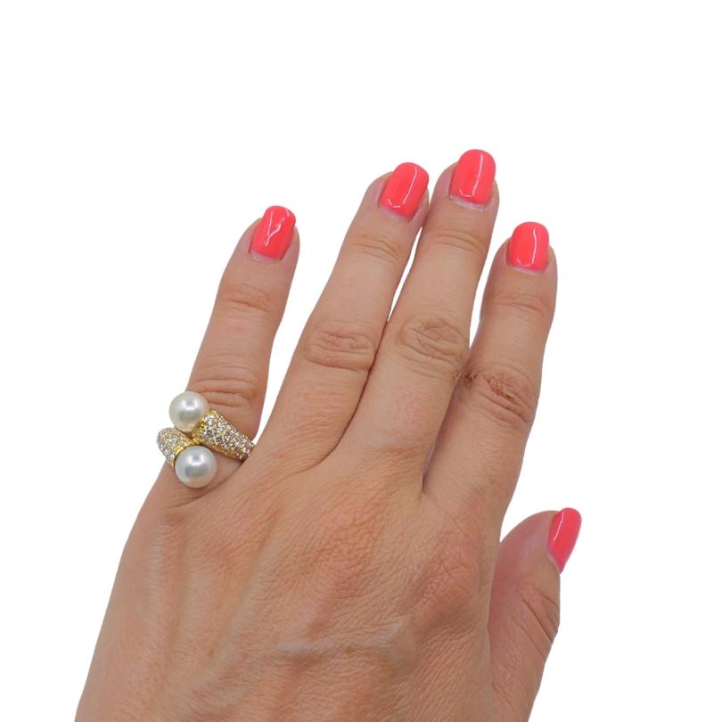 L'anello Van Cleef & Arpels Toi Et Moi è un pezzo sorprendente realizzato in oro giallo 18 carati, con due perle luminose disposte una leggermente sopra l'altra per una silhouette distintiva ed elegante. La fascia è parzialmente ornata da diamanti