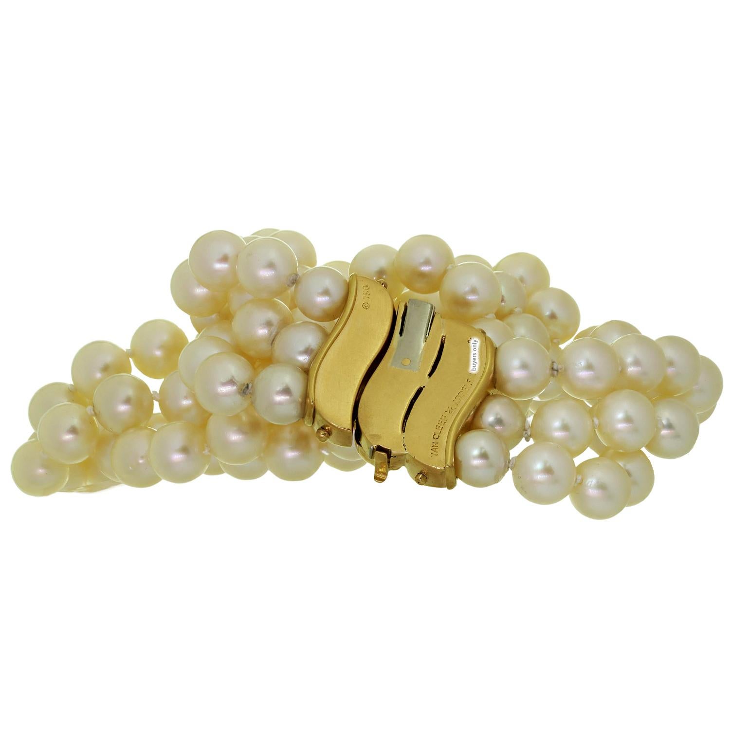 This exquisite vintage authentic Van Cleef & Arpels necklace features three strands of cultured pearls, a total of 143 pearls, creamy white in color, with medium luster, measuring 8.5mm - 9.0mm in diameter, complimented with an 18k yellow gold clasp