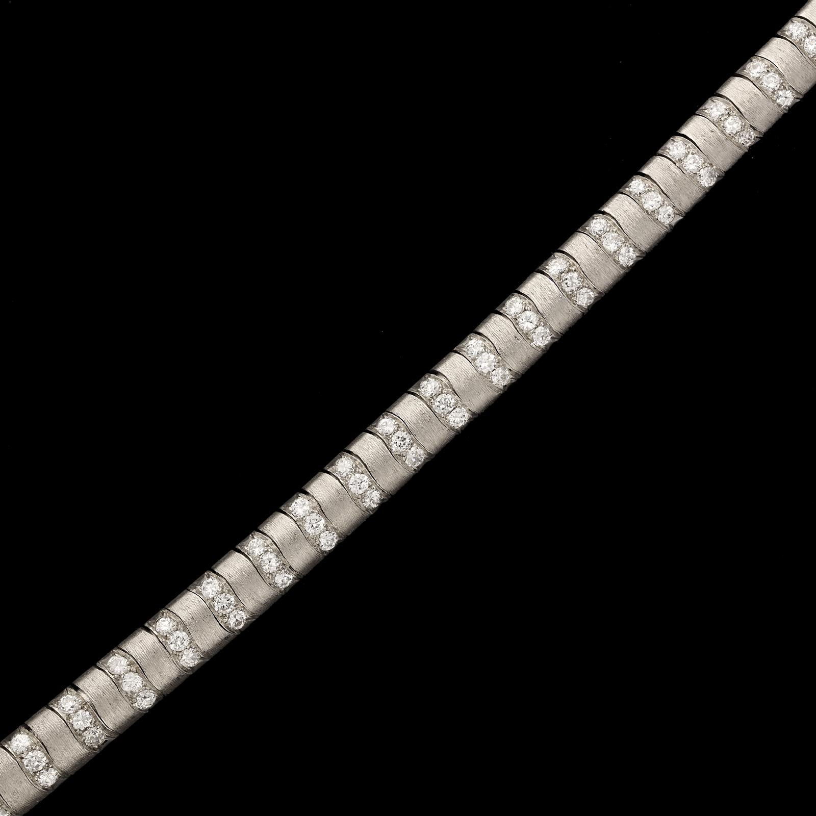 A striking and unusual platinum and diamond necklace by Van Cleef and Arpels c.1942, the articulated necklace made in platinum with a straight ribbon form and double domed profile, set across at regular intervals with sixty-three inlaid rows of