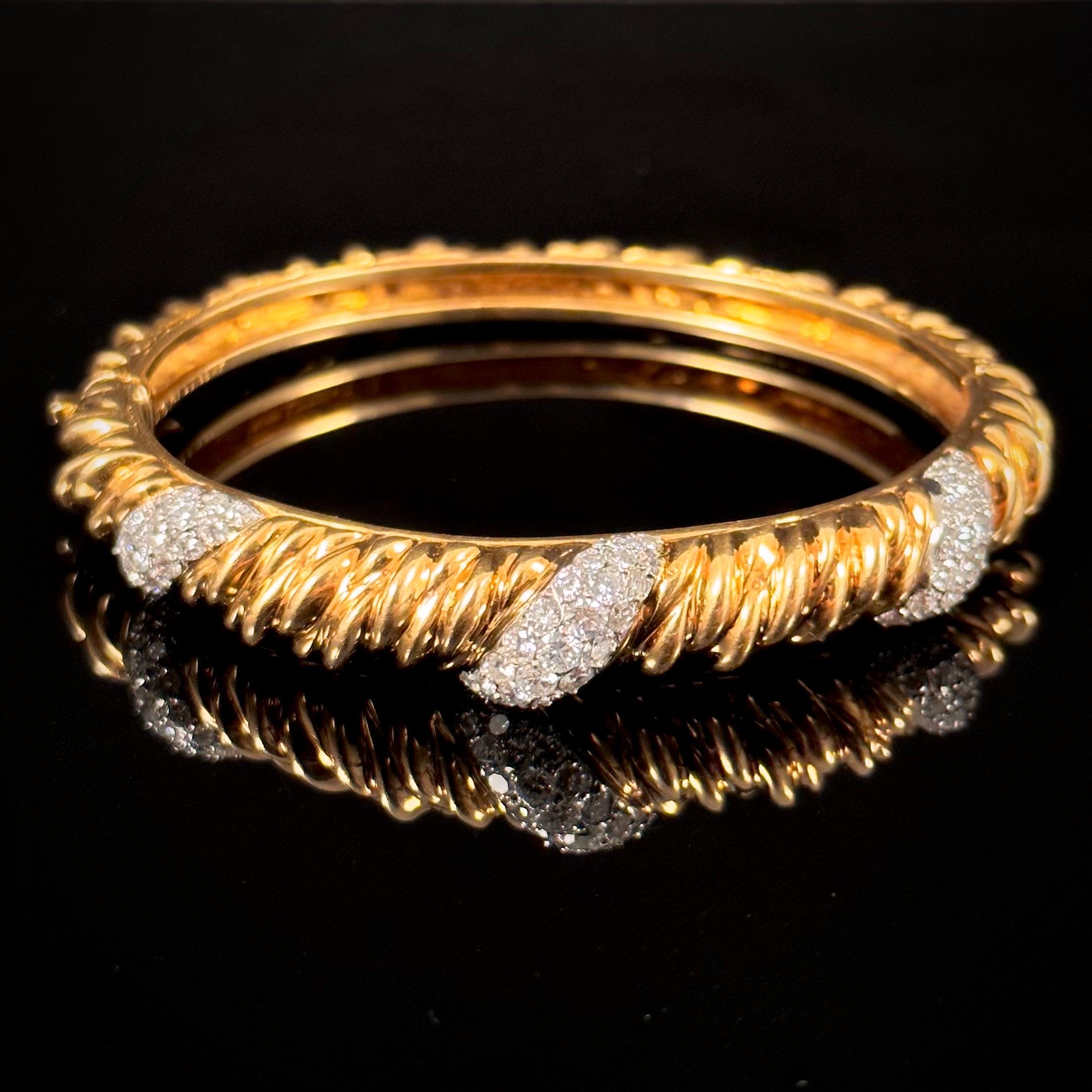 Van Cleef & Arpels VCA diamond ropework bangle bracelet in 18kt yellow gold and platinum, vintage from the 1970s, France. This two-part hinged bangle bracelet of an oval shape is designed with a twisted rope pattern in yellow gold, the top half