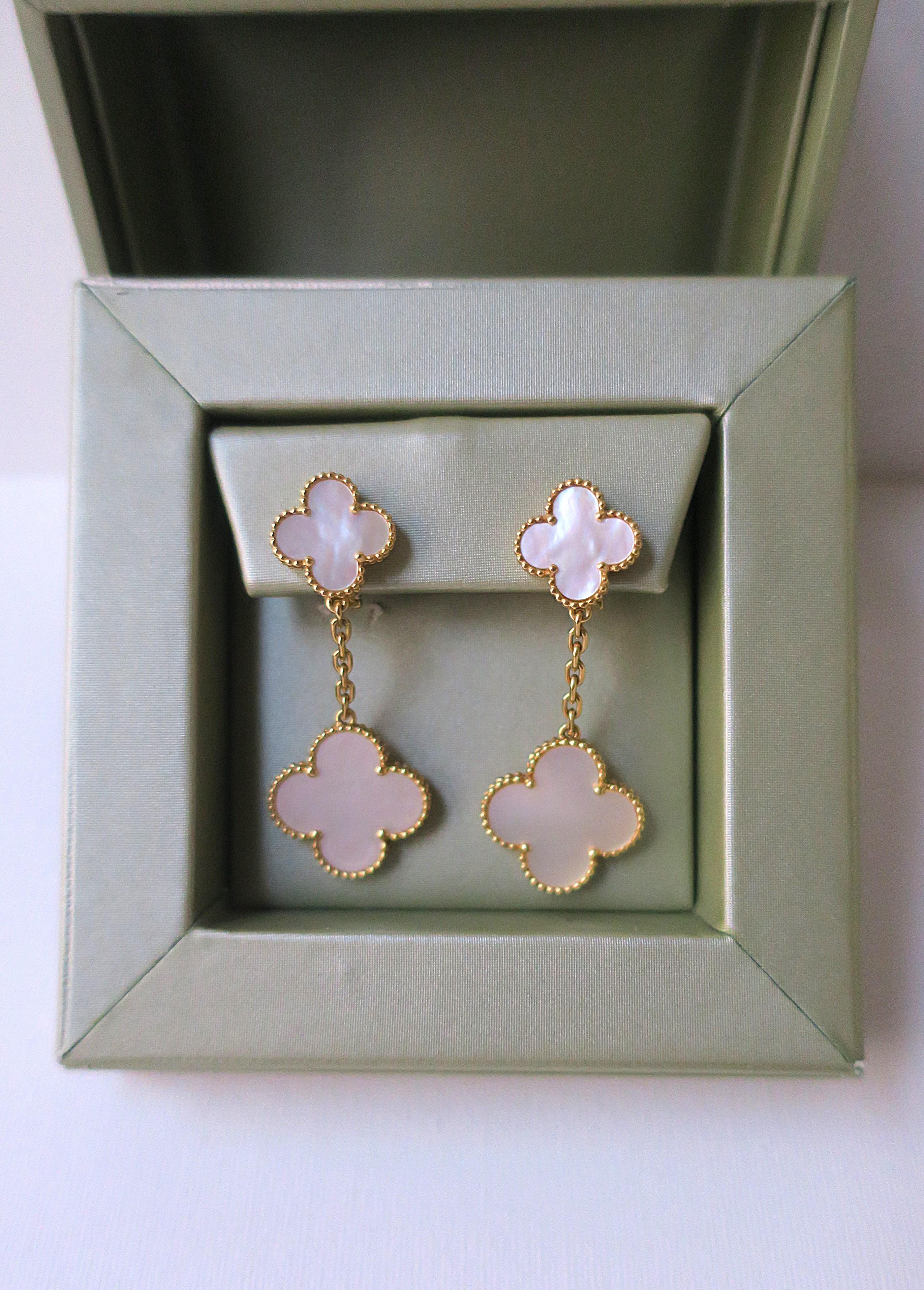 A very beautiful pair of Van Cleef & Arpels mother-of-pearl and 18-karat yellow gold Magic Alhambra 2-motif dangle or drop earrings, circa early-21st century, France. Made in France, purchased in New York, NY. Excellent condition as shown in images