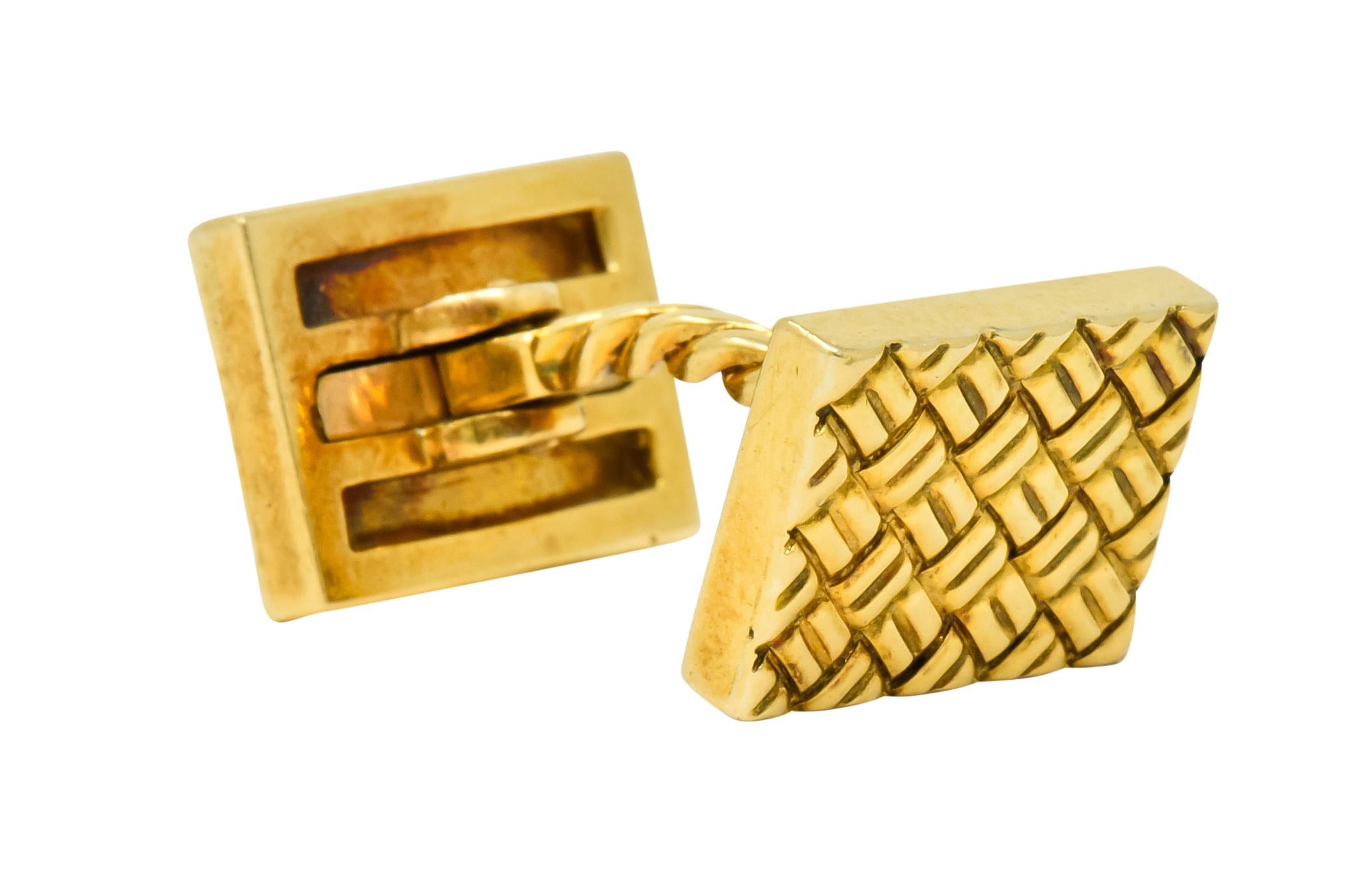 Lever style cufflinks terminating as two rectangles featuring a deeply engraved woven motif

With a twisted cable bar center

One cufflink signed VCA NY for Van Cleef & Arpels New York and numbered

Both stamped 18k for 18 karat gold

Length: 1