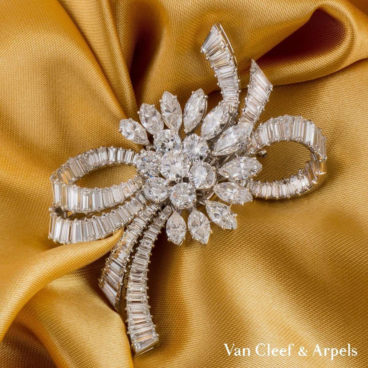 Exceptionnelle broche en diamants de Van Cleef & Arpels, c.C.1950. La grappe centrale de sept diamants ronds de taille brillant est entourée d'une demi-courbe extérieure de diamants marquise. Le diamant rond central de taille brillant pèse 0,65ct