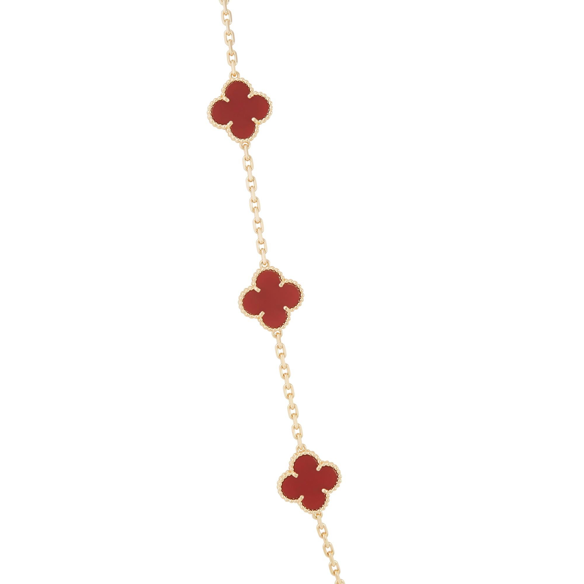 Authentic Van Cleef & Arpels 18 karat yellow gold long necklace featuring 20 clover leaf inspired motifs set with carved carnelian stones. The Necklace measures 33 1/2 inches in length. Signed VCA, Au750 with serial number and hallmarks.  Necklace