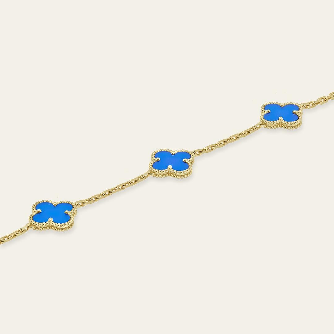 Esta pulsera Van Cleef & Arpels Vintage Alhambra está elaborada en oro amarillo de 18 quilates y presenta cinco impresionantes motivos de ágata azul. Cada piedra es única, con variaciones naturales de color y textura, que hacen que cada pieza sea