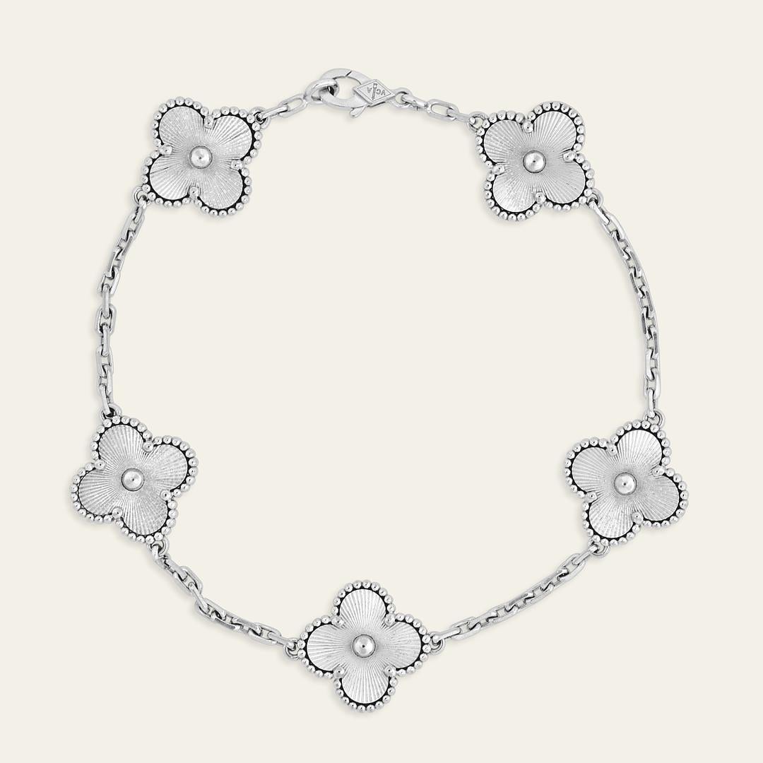 Esta pulsera Van Cleef & Arpels Vintage Alhambra presenta cinco motivos icónicos elaborados en oro blanco de 18 quilates rodiado con un impresionante acabado guilloché. Esta pulsera Val Cleef está diseñada con un cierre distintivo para llevarla con