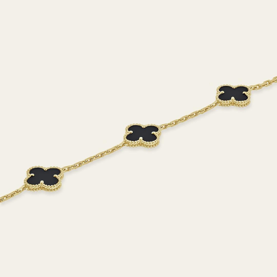 La pulsera Van Cleef & Arpels Vintage Alhambra está elaborada en oro amarillo de 18 quilates y presenta cinco exquisitos motivos de ónice. Cada piedra de ónice es única, con variaciones naturales de color y textura que contribuyen al encanto