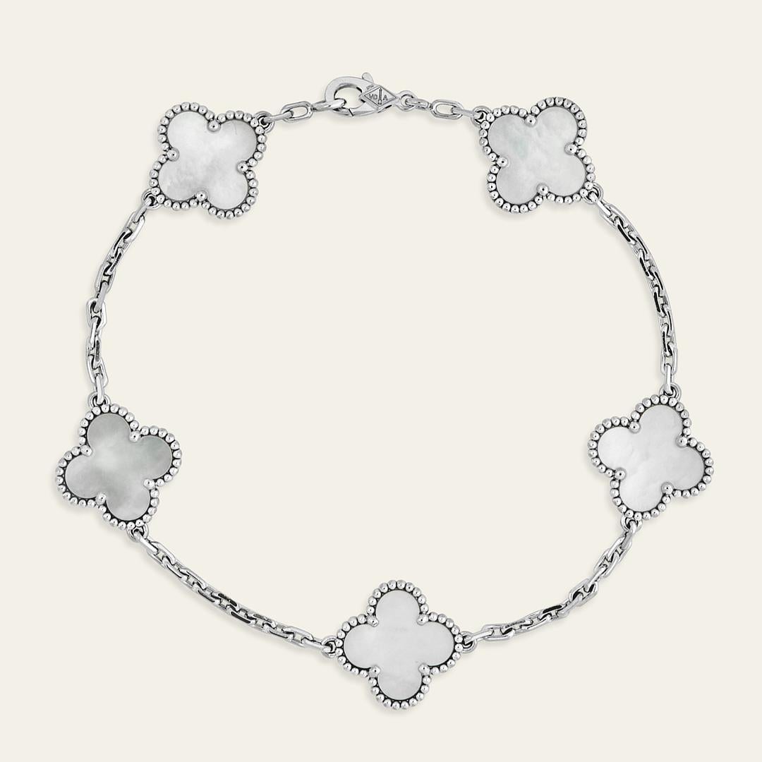 Esta pulsera Van Cleef & Arpels Vintage Alhambra luce cinco elegantes motivos de nácar blanco, engastados en oro blanco de 18 quilates rodiado. Cada piedra es única, con variaciones naturales de color y textura, que añaden individualidad a la