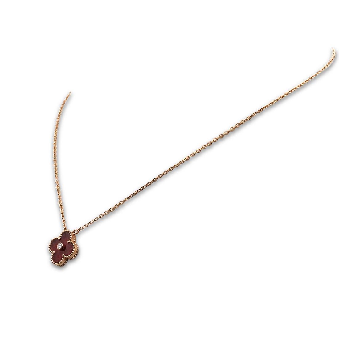 Authentic Van Cleef & Arpels limited edition 'Vintage Alhambra' pendant necklace crafted in 18 karat rose gold features a single clover-inspired motif set with carnelian and one round brilliant cut diamond with an estimated .05 total carat weight.