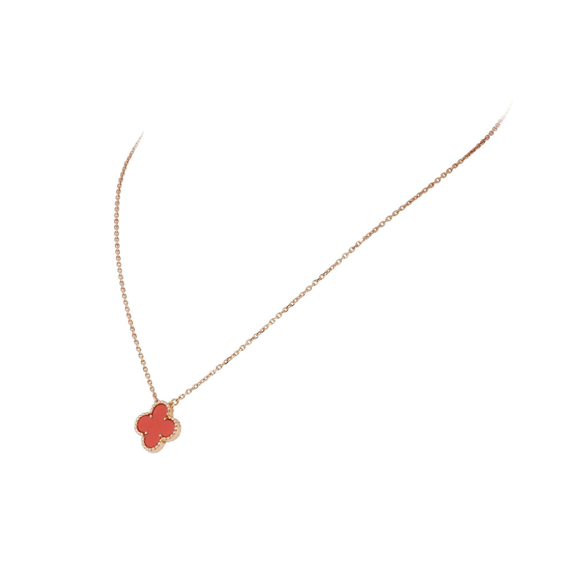 Authentic Van Cleef & Arpels 'Vintage Alhambra' necklace crafted in 18 karat yellow gold and featuring one clover-shaped motif in carved coral. The pendant hangs from a 16 3/4 inch adjustable chain.  Signed VCA, Au750, with serial number and French