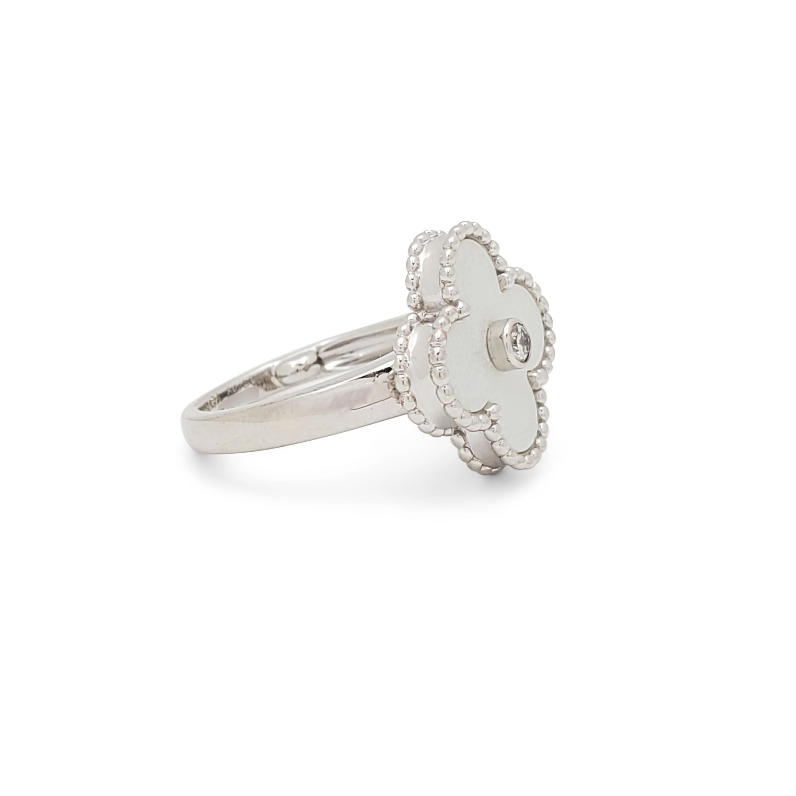 Authentic Van Cleef & Arpels 'Vintage Alhambra' ring crafted in 18 karat white gold centers on a clover motif in mother-of-pearl set with a round brilliant cut diamond center weighing an estimated 0.06 carats (E-F color, VS clarity). Signed VCA,