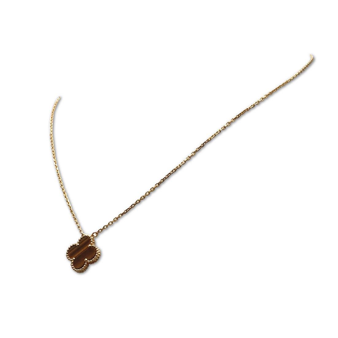 Authentic Van Cleef & Arpels 'Vintage Alhambra' pendant necklace crafted in 18 karat yellow gold features a single clover-inspired motif set with one Tiger's eye stone. Signed VCA, Au750, with serial number. The adjustable chain measures 16 1/2