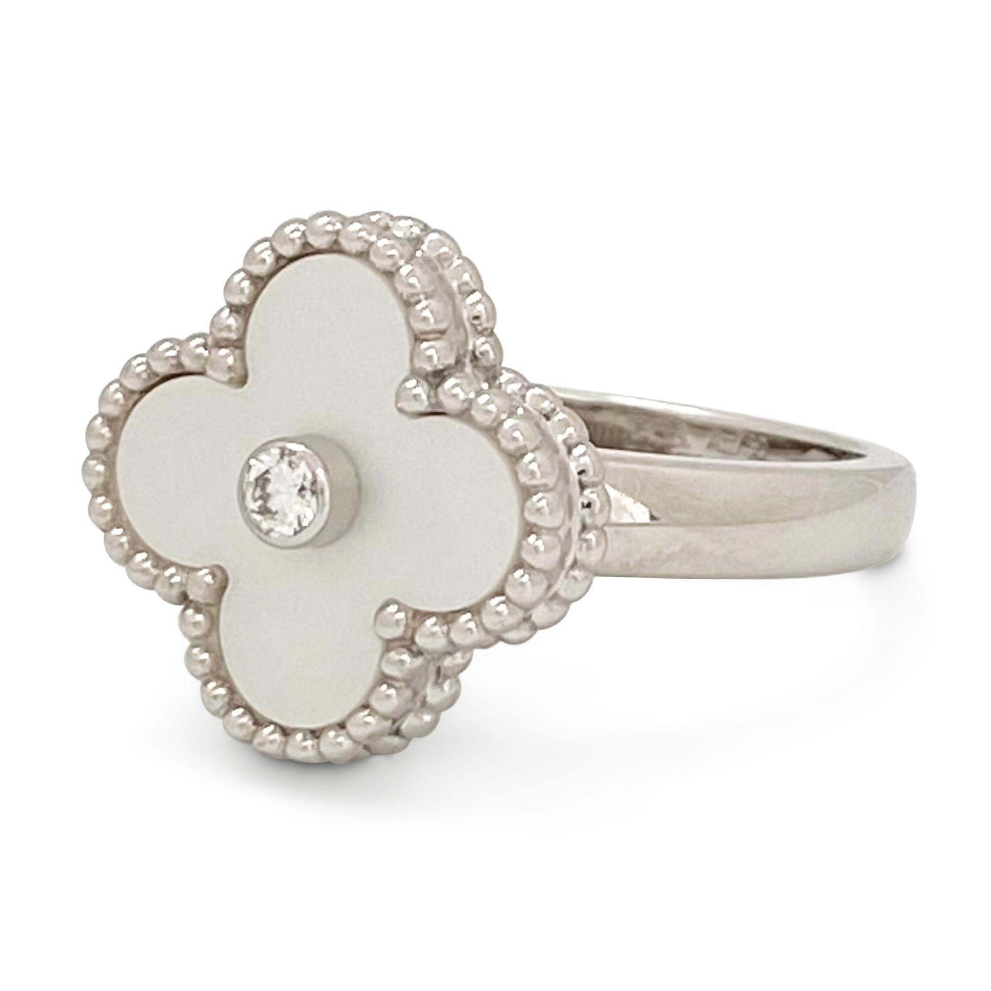 Authentic Van Cleef & Arpels 'Vintage Alhambra' ring crafted in 18 karat white gold centers on a clover motif in mother-of-pearl set with a round brilliant cut diamond center weighing an estimated 0.06 carats (E-F color, VS clarity). Signed VCA,