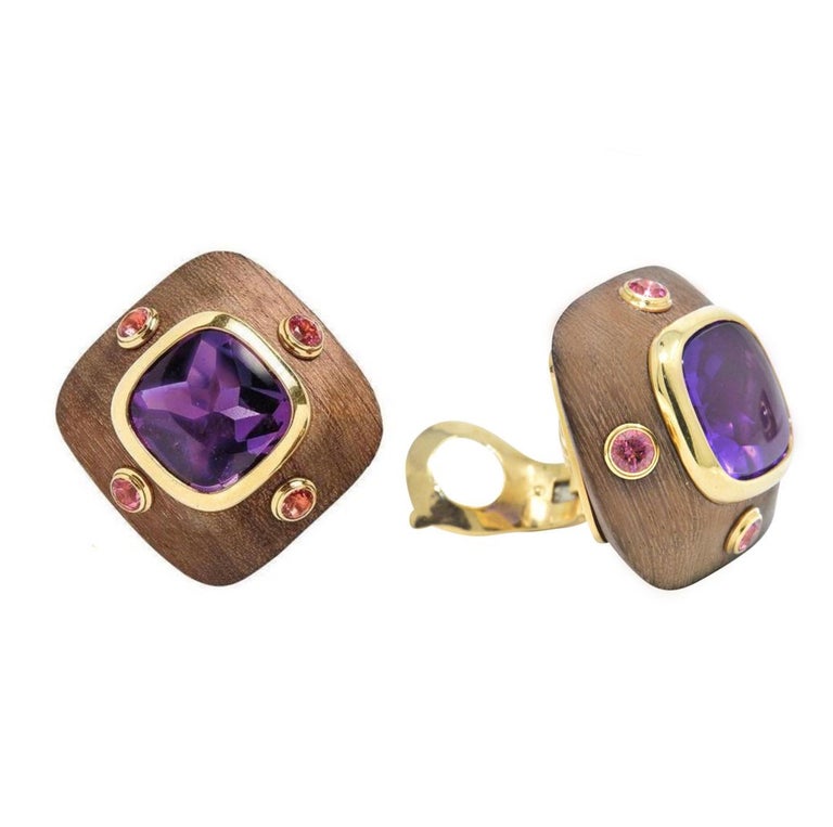 1970's Van Cleef & Arpels amethyst, wood and pink tourmaline earrings in 18k yellow gold, each
composed of cushionshape wood, centered with a bezel set cushion cut buff-top amethyst and
accented with 4 bezel set round brilliant cut pink tourmalines.