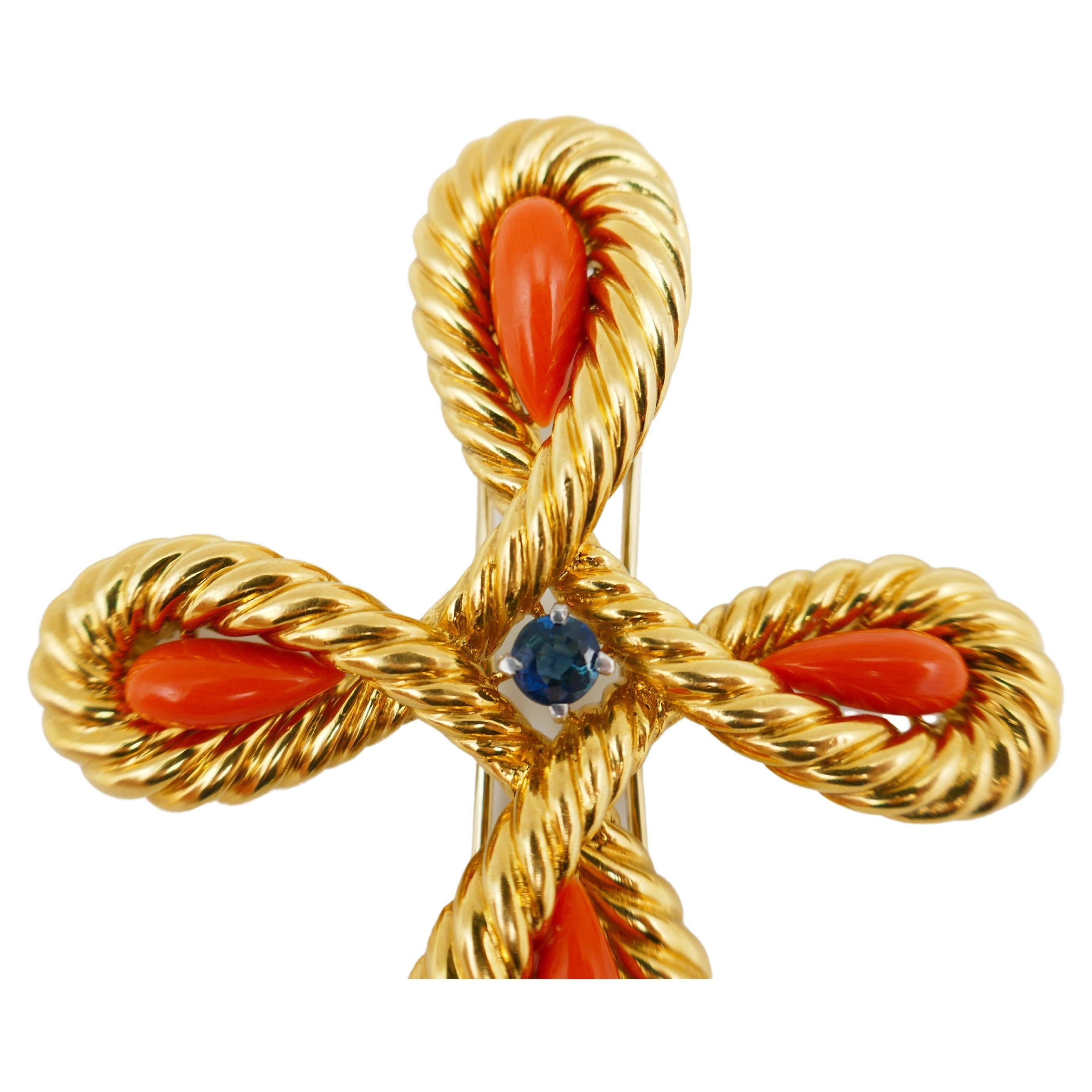 An impressive vintage piece by Van Cleef & Arpels. A brooch/pendant made of 18k yellow braided gold, cabochon coral and sapphire. The bail and pin sticks have a releasing mechanism on the back of the brooch (see close-up photos). 
Stamped with VCA