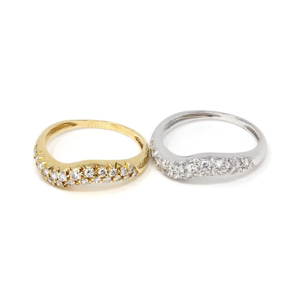 A set of two tone diamond bands by the iconic french house of Jewelry Van Cleef and Arpels. The rings and designed on top In a wavy fashion with pavé set diamonds G color and VS-VVS Clarity. One band is 18k white gold and the other is 18k yellow