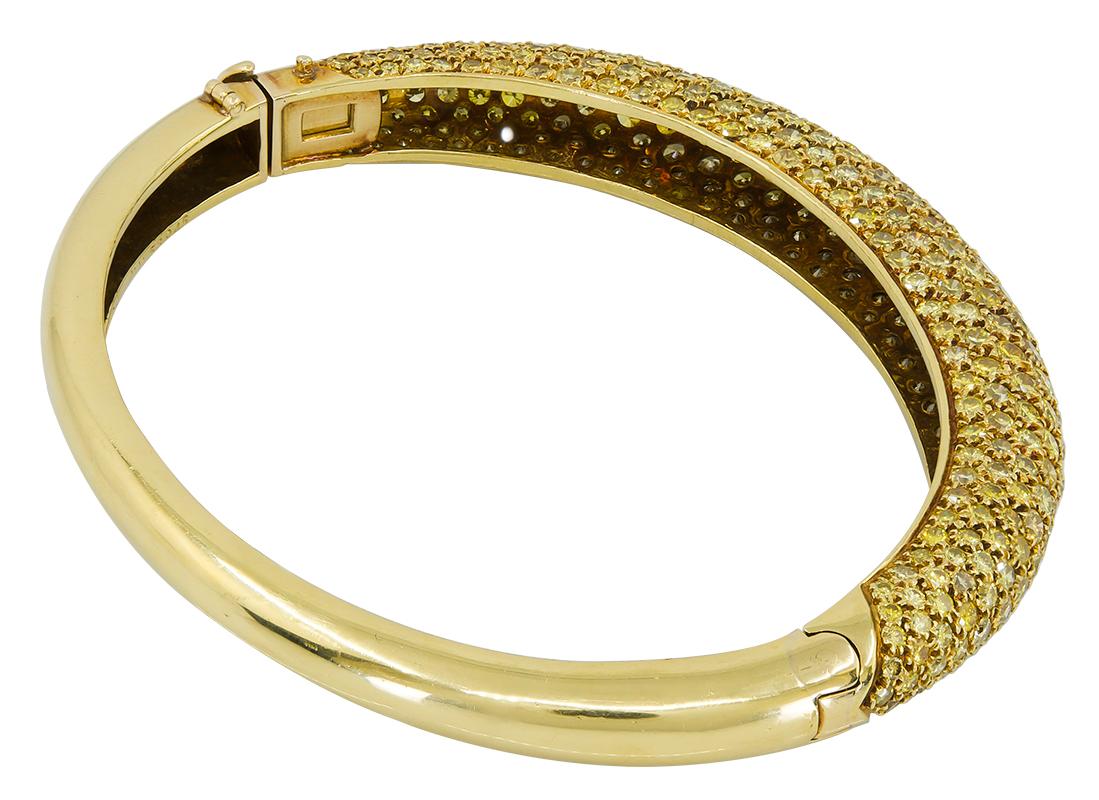 Bracelet en or jaune 18k Van Cleef & Arpels avec diamants jaunes.

Un bracelet charnière classique de Van Cleef & Arpels datant des années 1970, conçu comme un fin bangle en forme de bombé. La moitié supérieure de la pièce comporte neuf rangées de