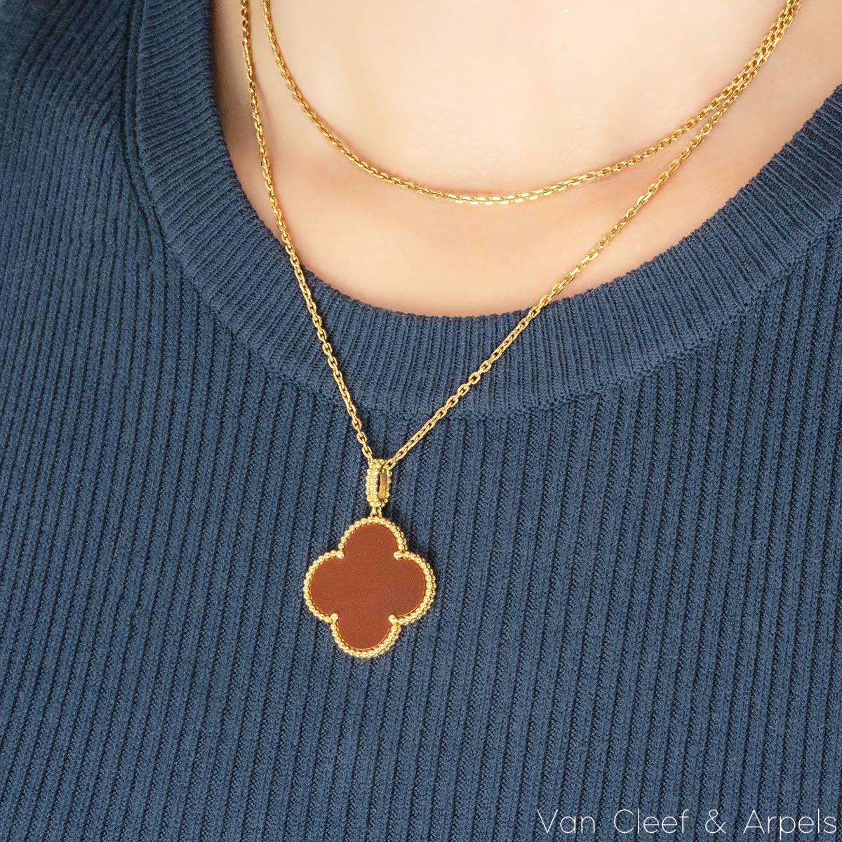 Un magnifique sautoir en or jaune 18 carnelian de Van Cleef & Arpels de la collection Magic Alhambra. Le collier comprend le pendentif emblématique à motif de trèfle à quatre feuilles, serti d'une incrustation de cornaline et complété par un bord