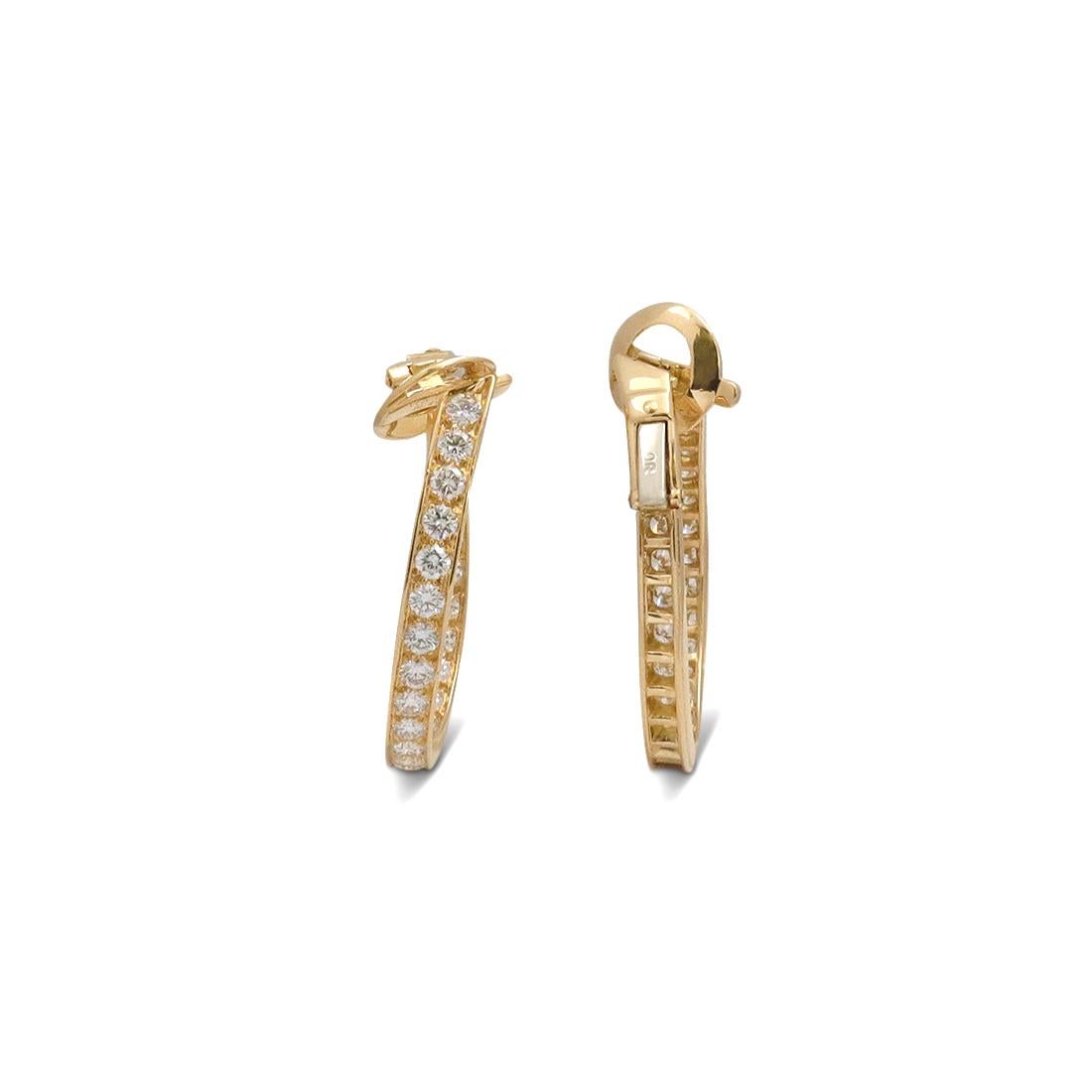 Authentic Van Cleef & Arpels hoop earrings crafted in 18 karat yellow gold. The twisted oval shaped earrings are set front to back with dazzling round brilliant cut diamonds weighing an estimated 5.50 carats total (G-H color, VS clarity). The